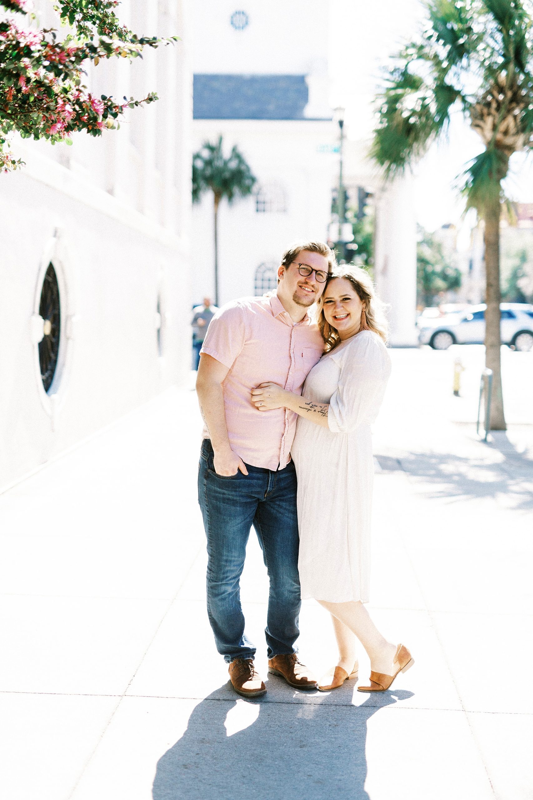 woman hugs husband during photos for anniversary in downtown Charleston
