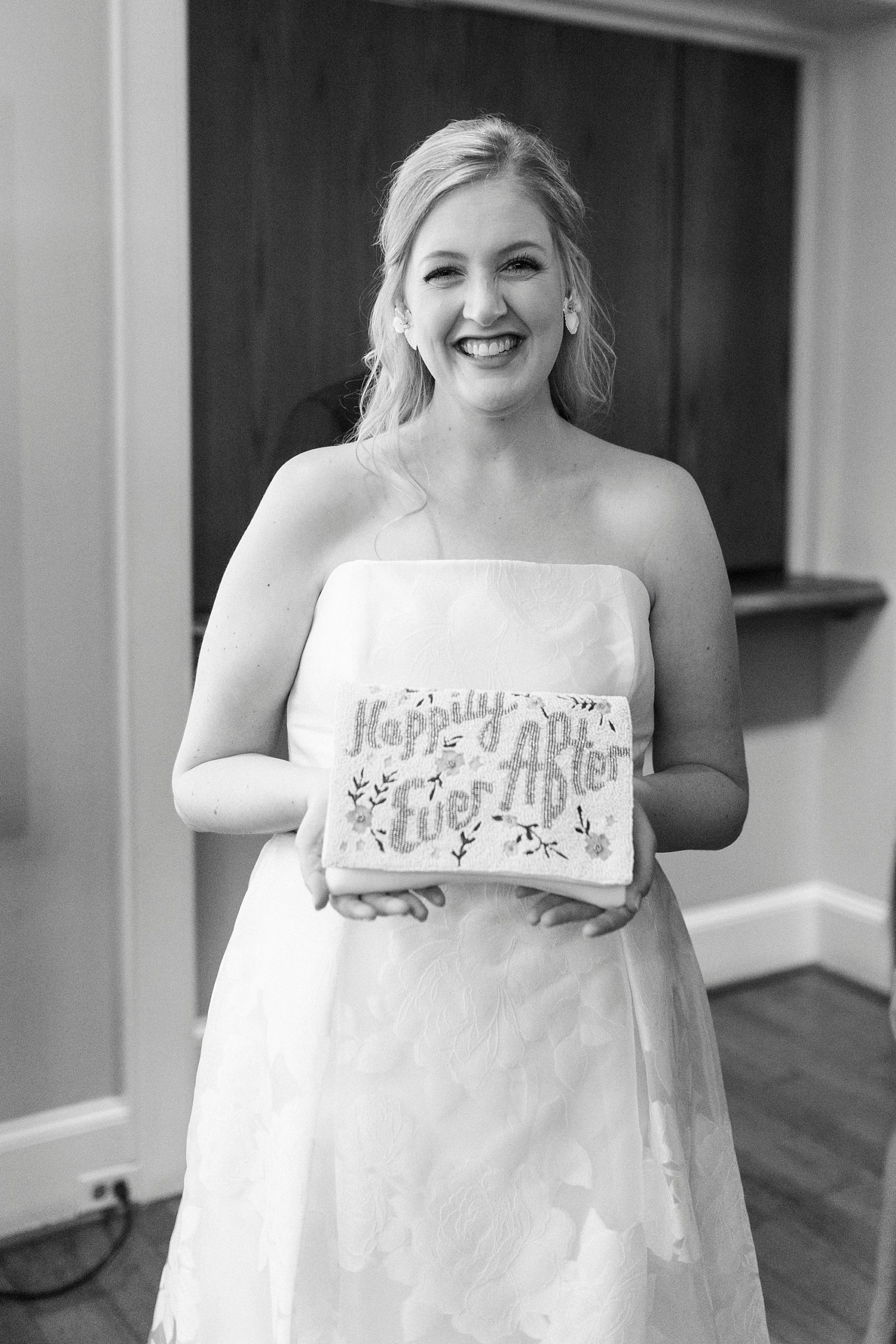bride holds custom box before Hotel Concord wedding
