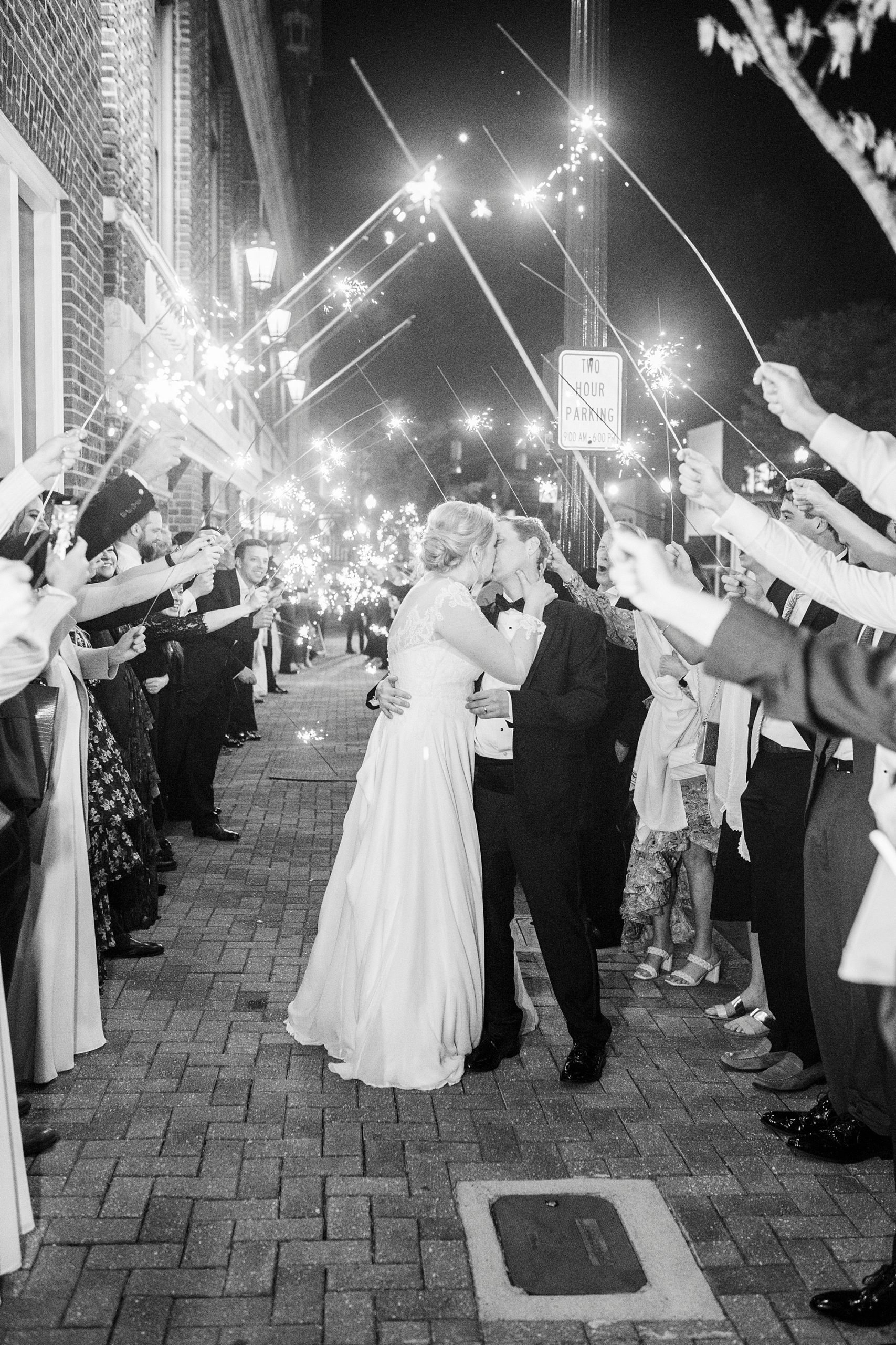 couple kisses during sparkler exit from Concord NC wedding reception