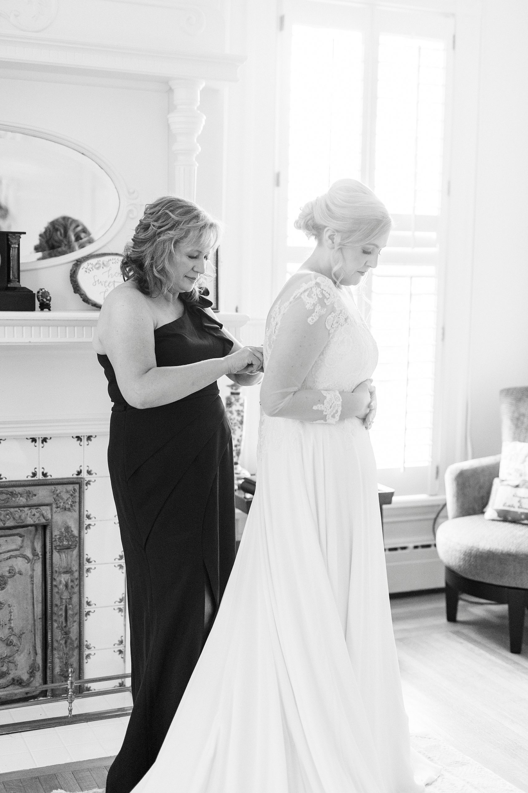 mother helps bride into wedding gown for Hotel Concord wedding