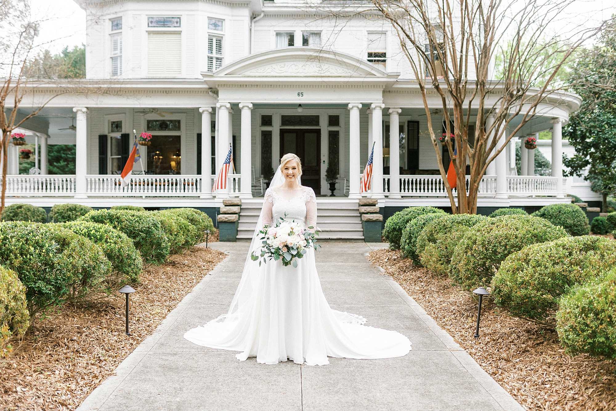 bride stands in walkway of historic home in Concord NC