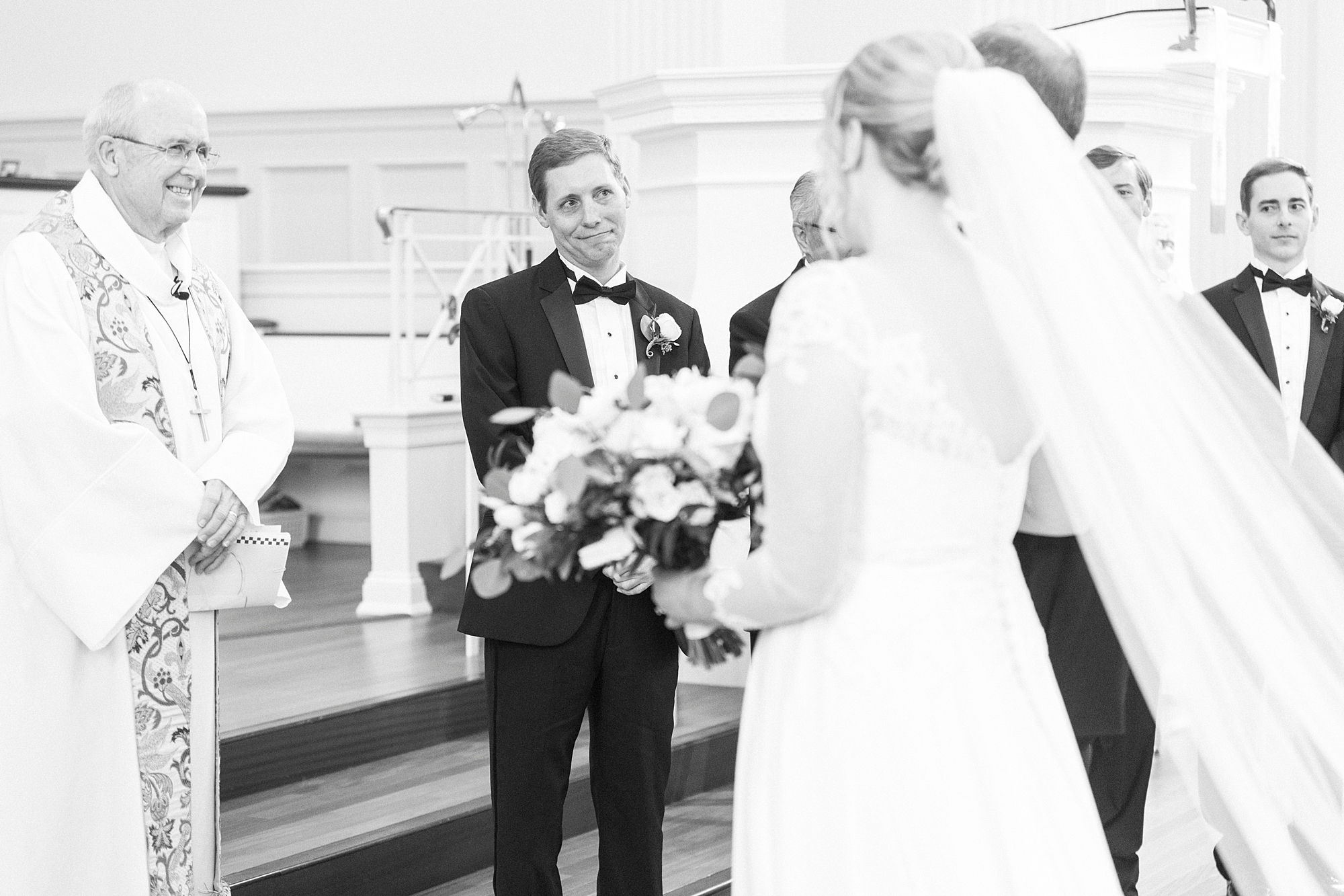 groom smile at bride by altar during traditional church wedding in Concord NC