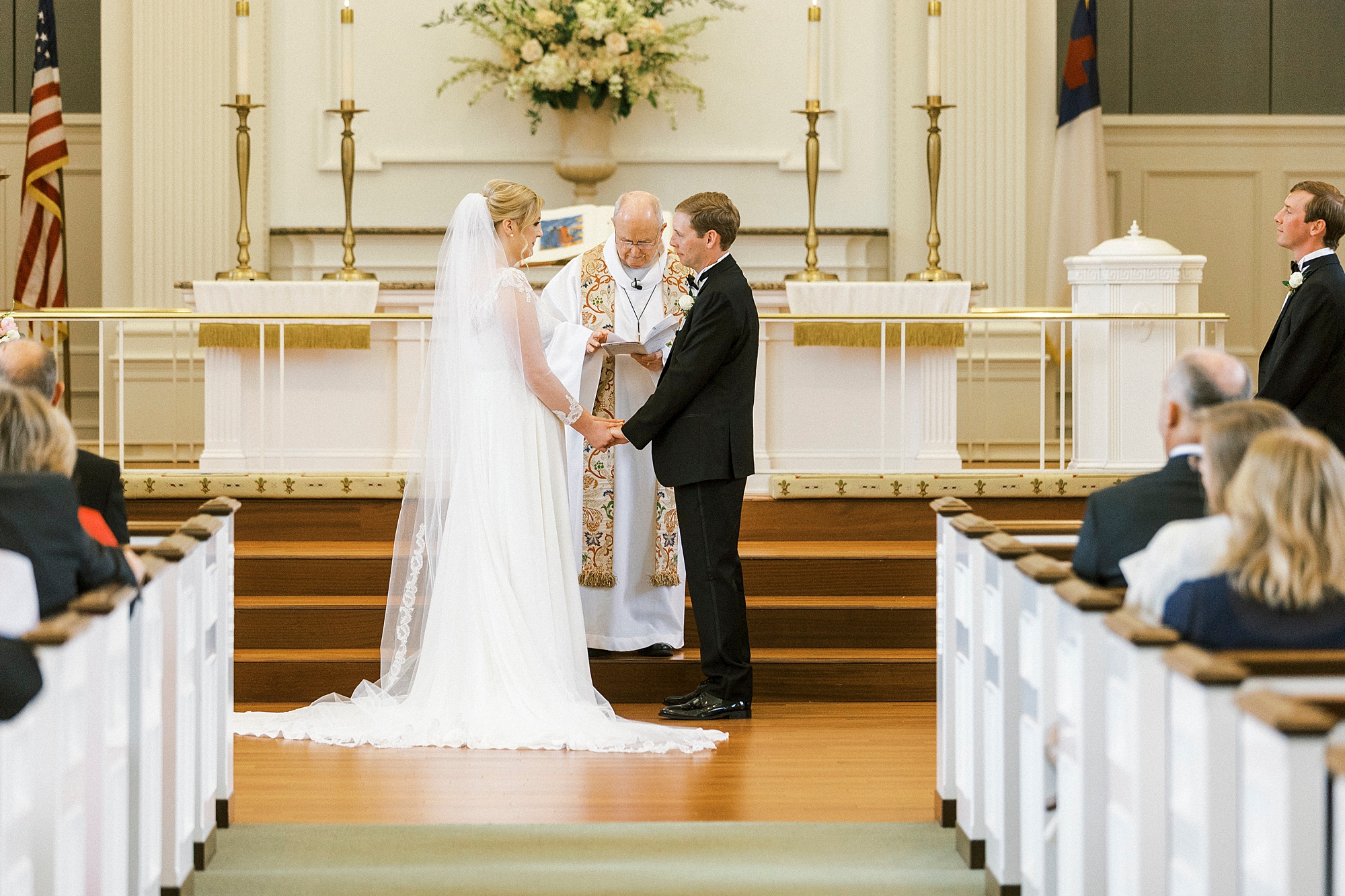 bride and groom hold hands during vows