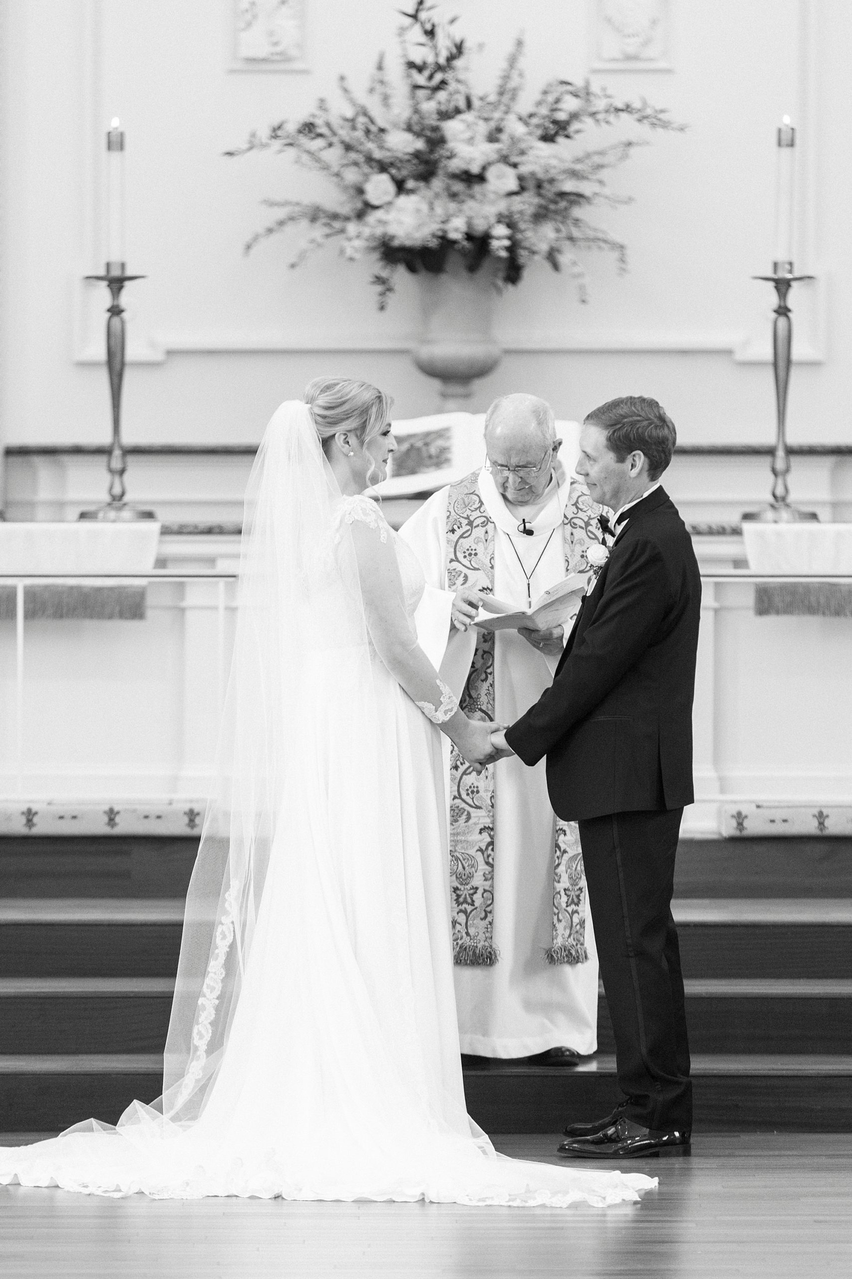 couple holds hands during traditional church wedding in Concord NC
