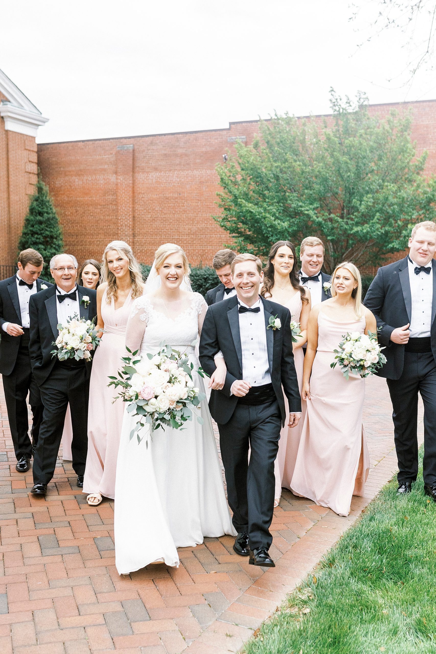 bride and groom walk with wedding party in Concord NC