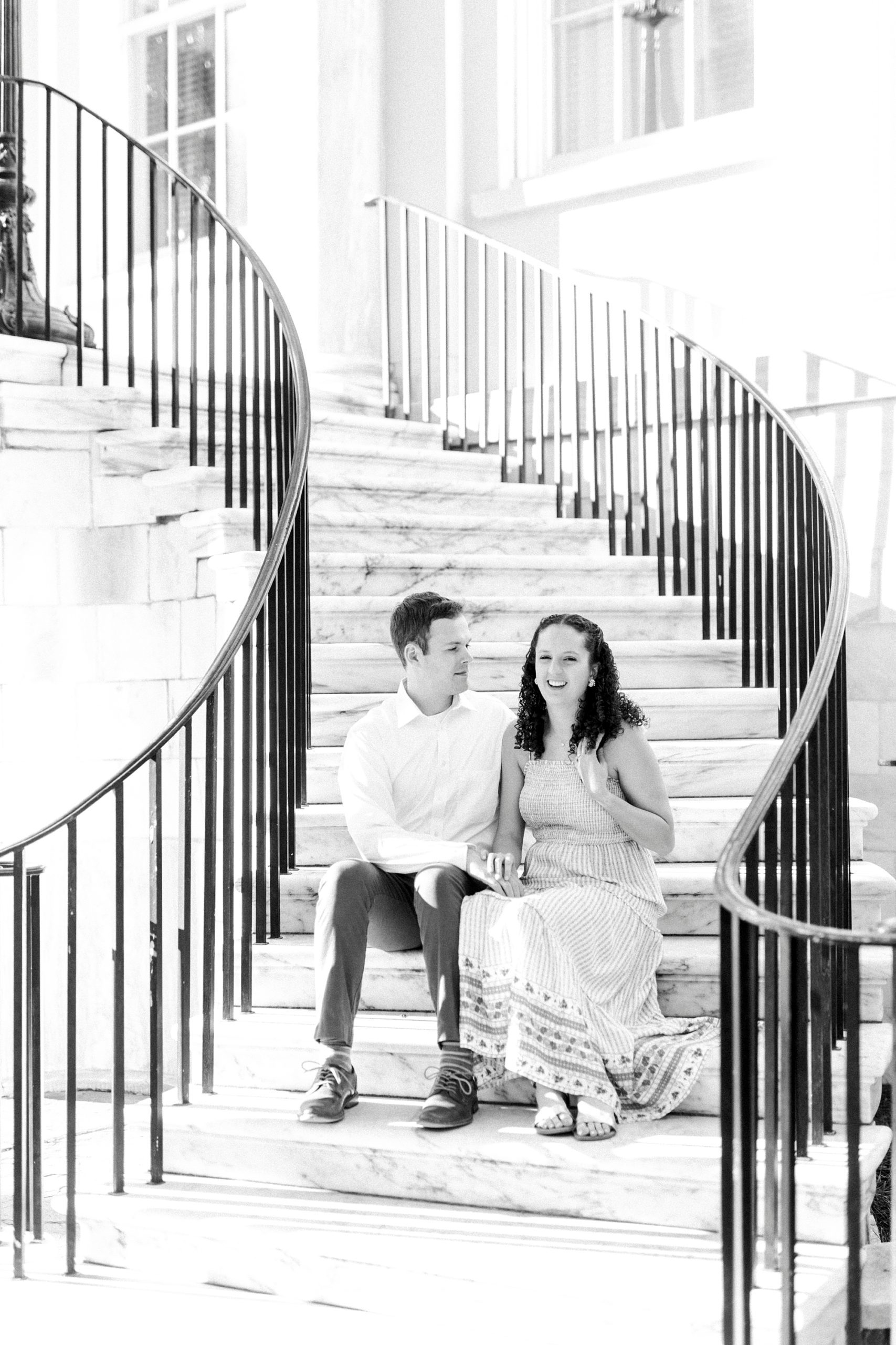 married couple sits on steps in Downtown Charleston 