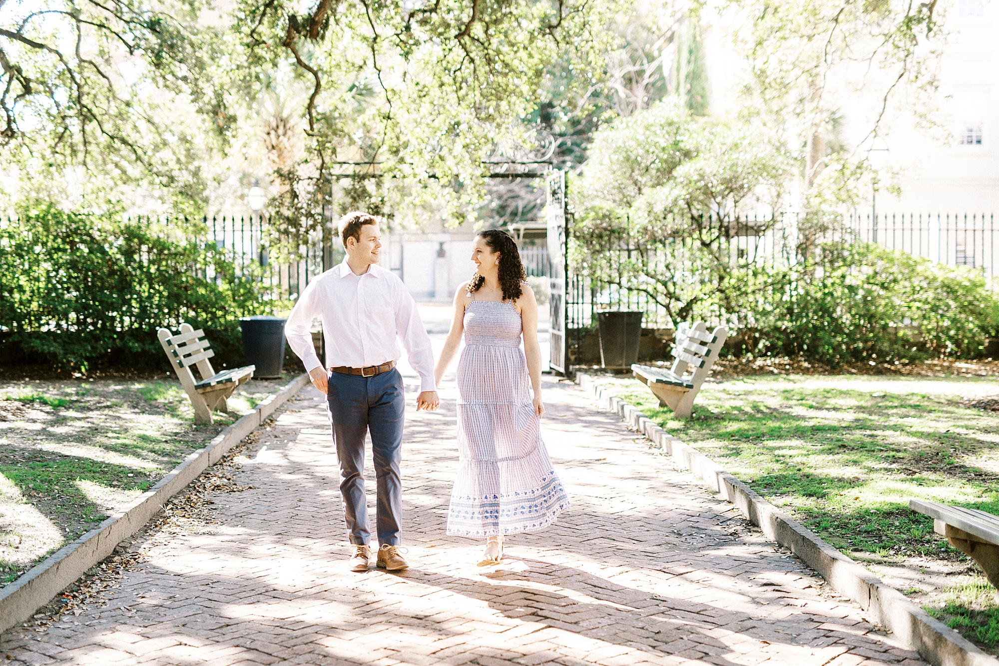 husband and wife walk through Charleston park
