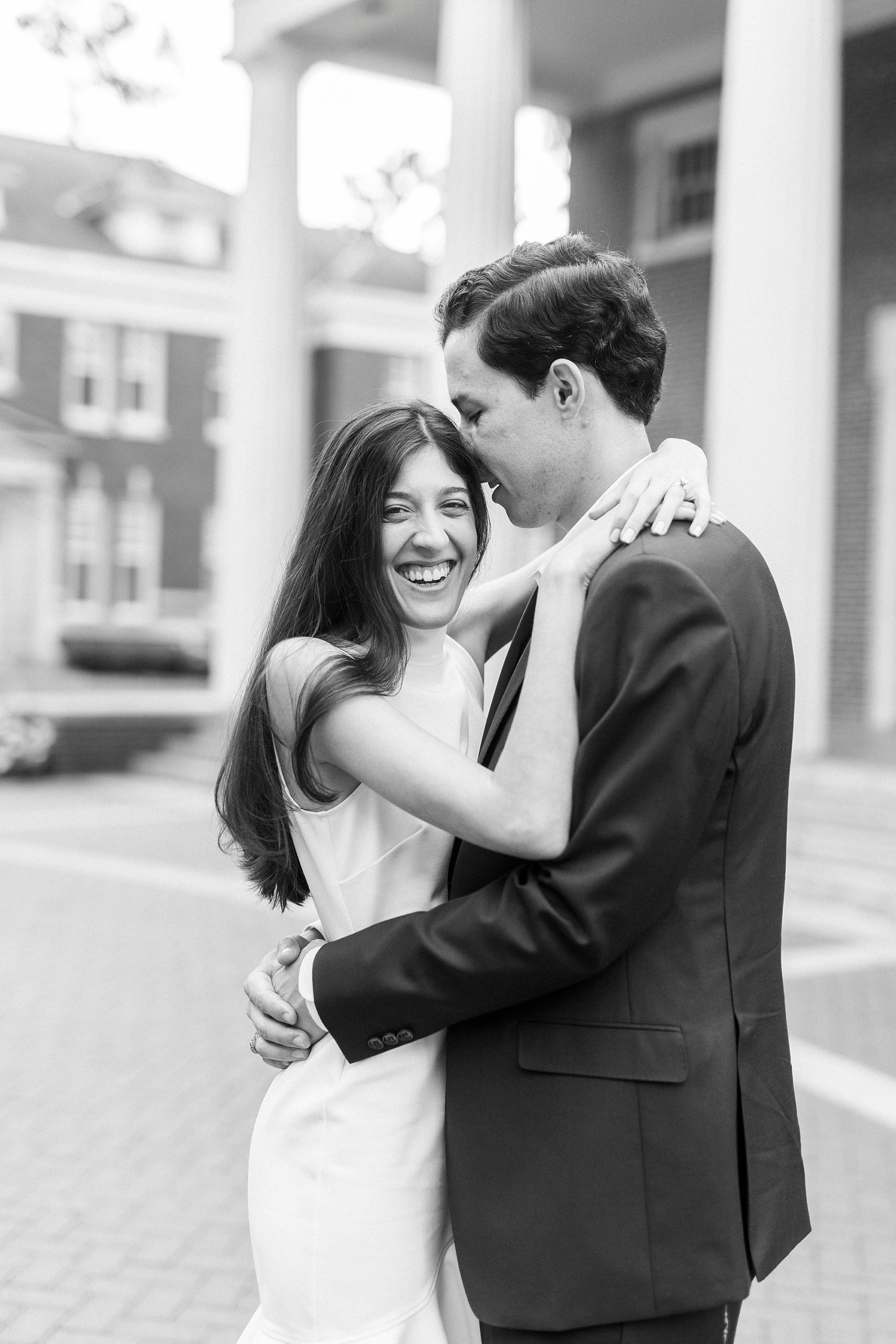 bride and groom laugh during Queens University engagement photos 