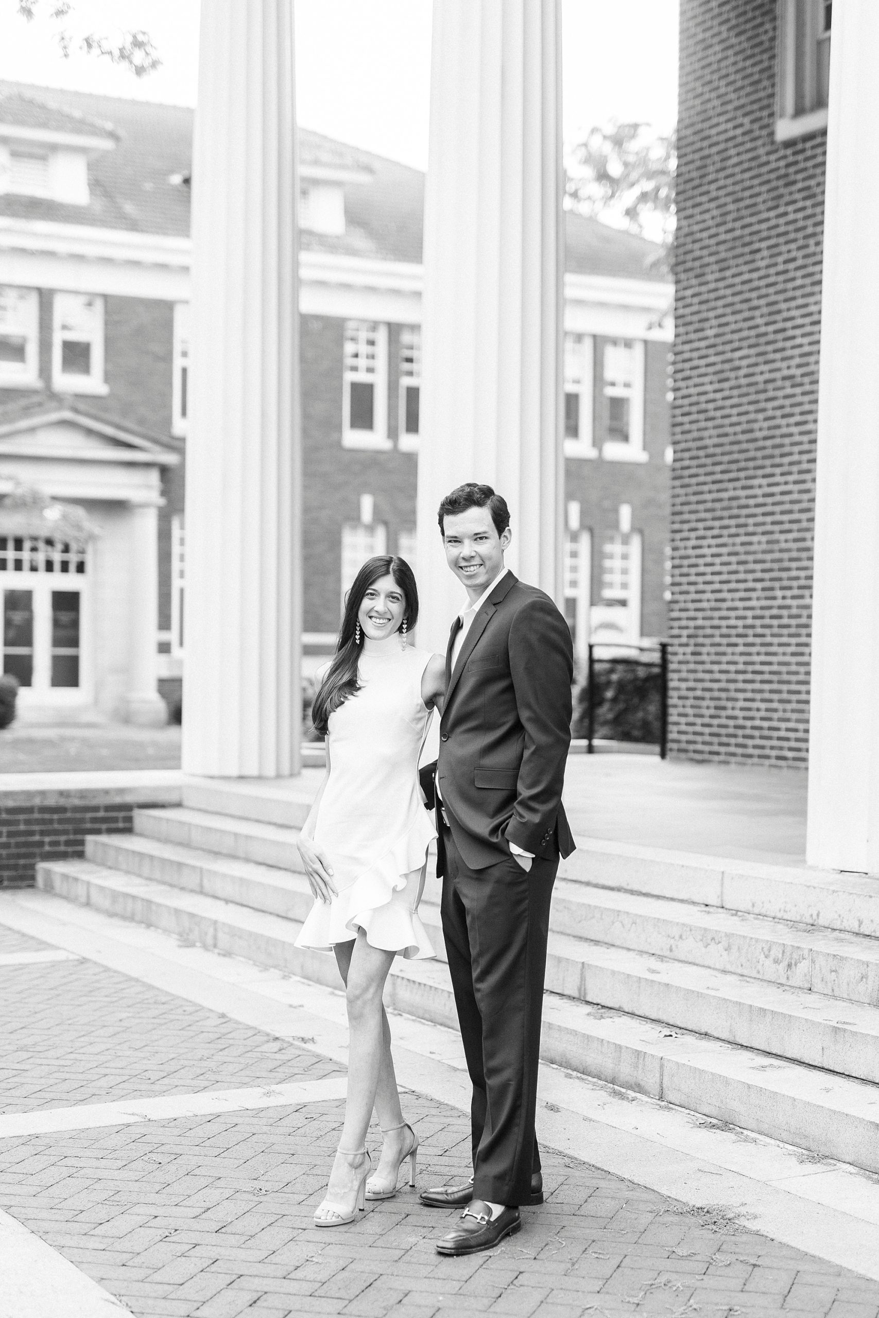 engaged couple sits on brick patio during Queens University engagement session
