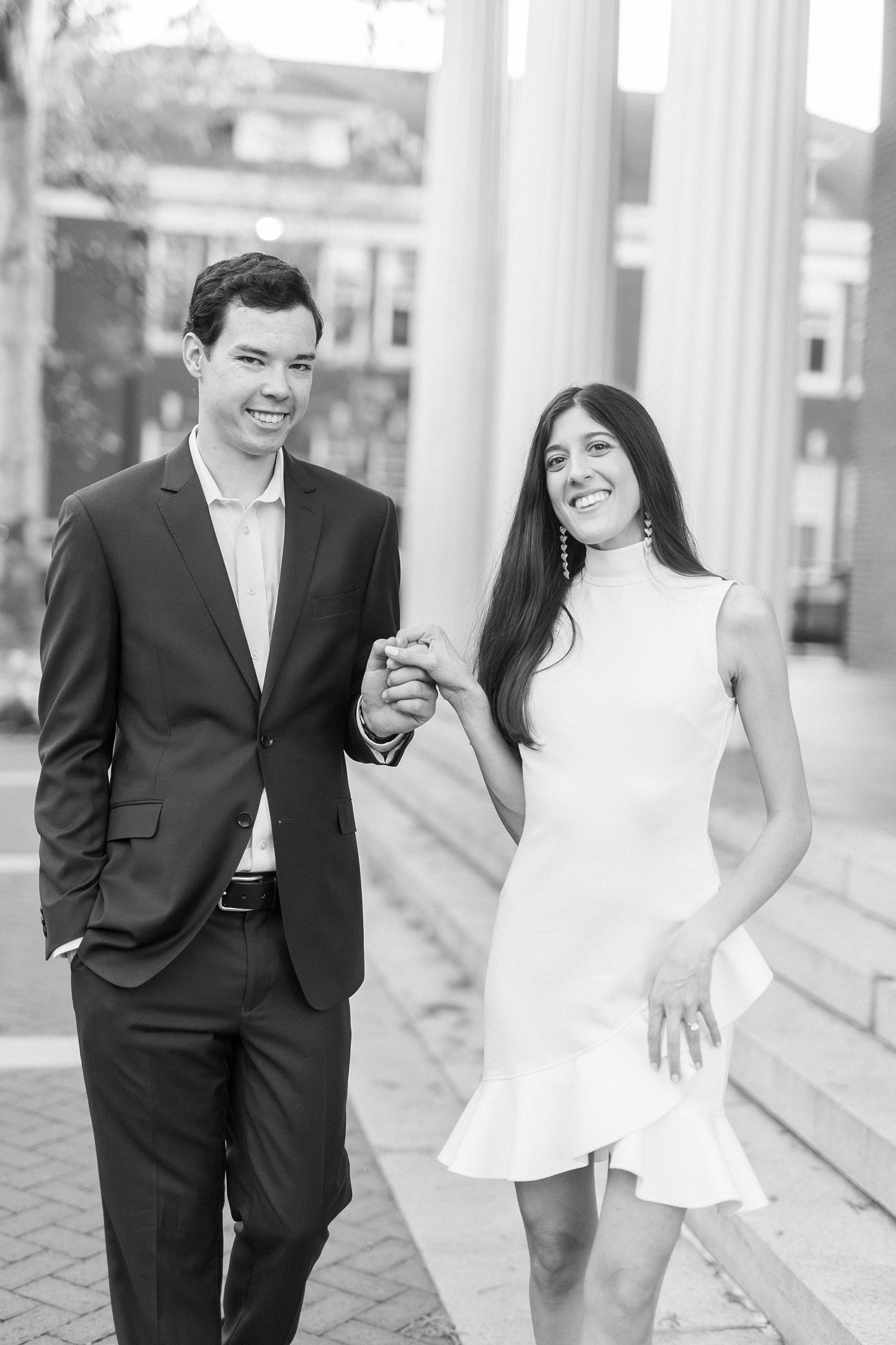 bride and groom hold hands walking along steps at Queens University