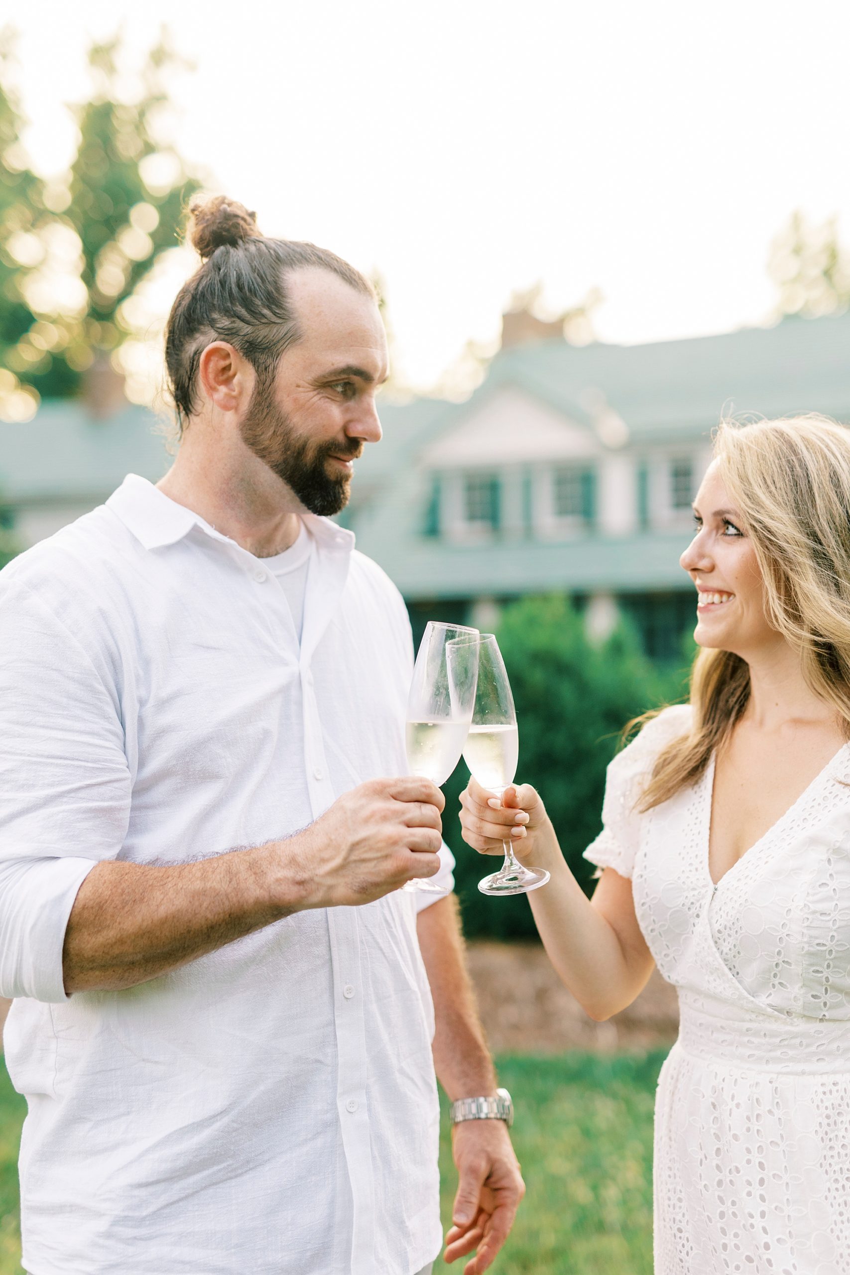 bride and groom toast champagne during Reynolda Gardens engagement session