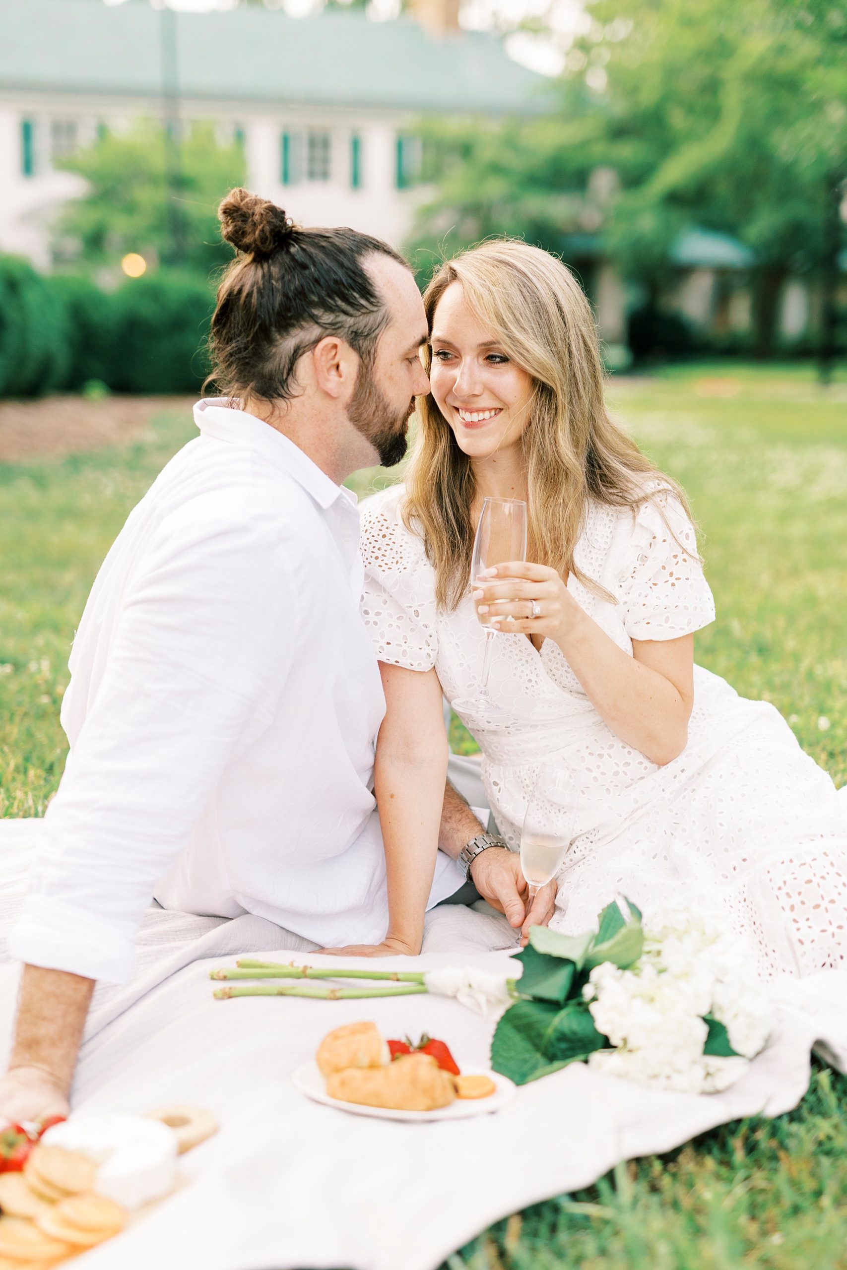 groom nuzzles bride's cheek during picnic 