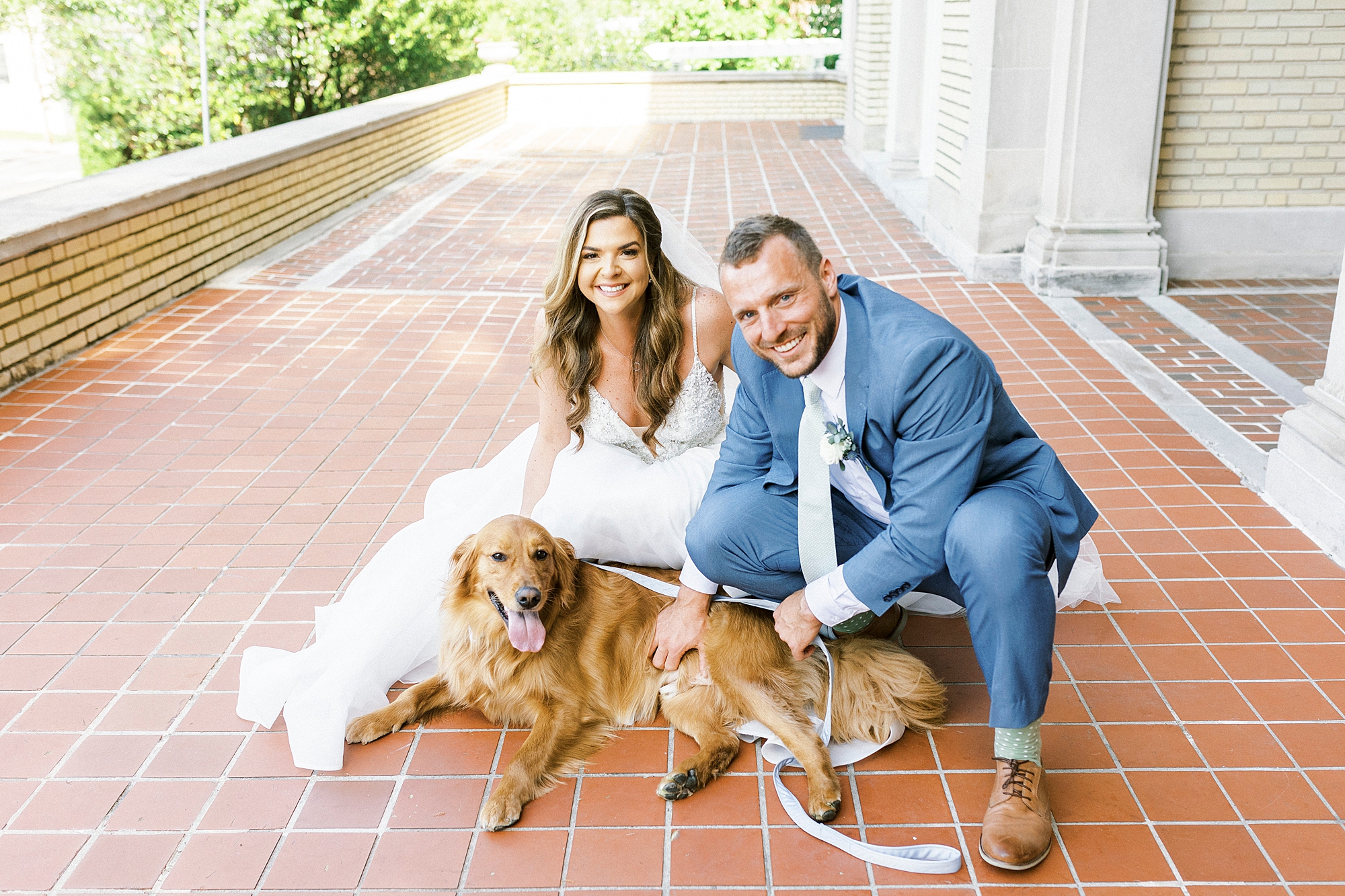 bride and groom sit with golden retriever on brick patio at Separk Mansion