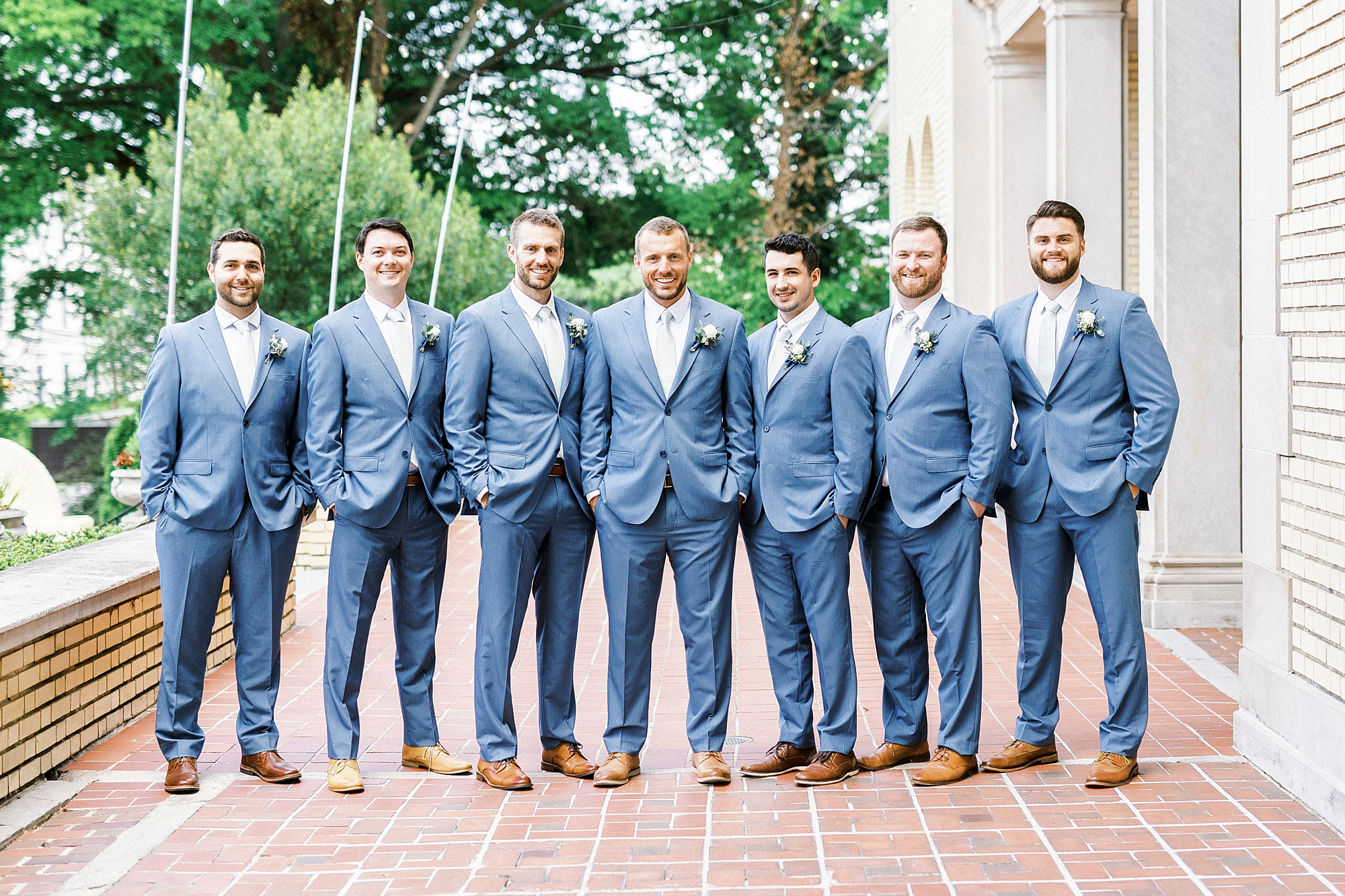 groom and groomsmen in navy suits stand on patio at Separk Mansion