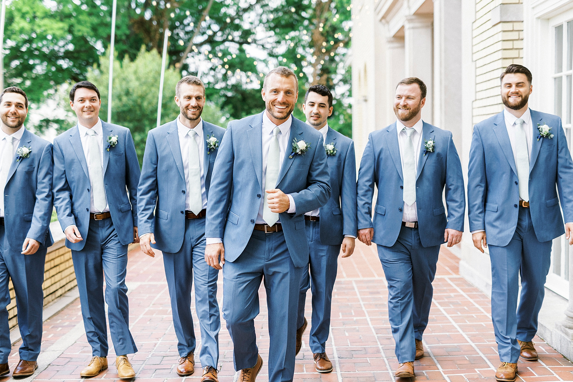 groom walks with groomsmen on patio at Separk Mansion