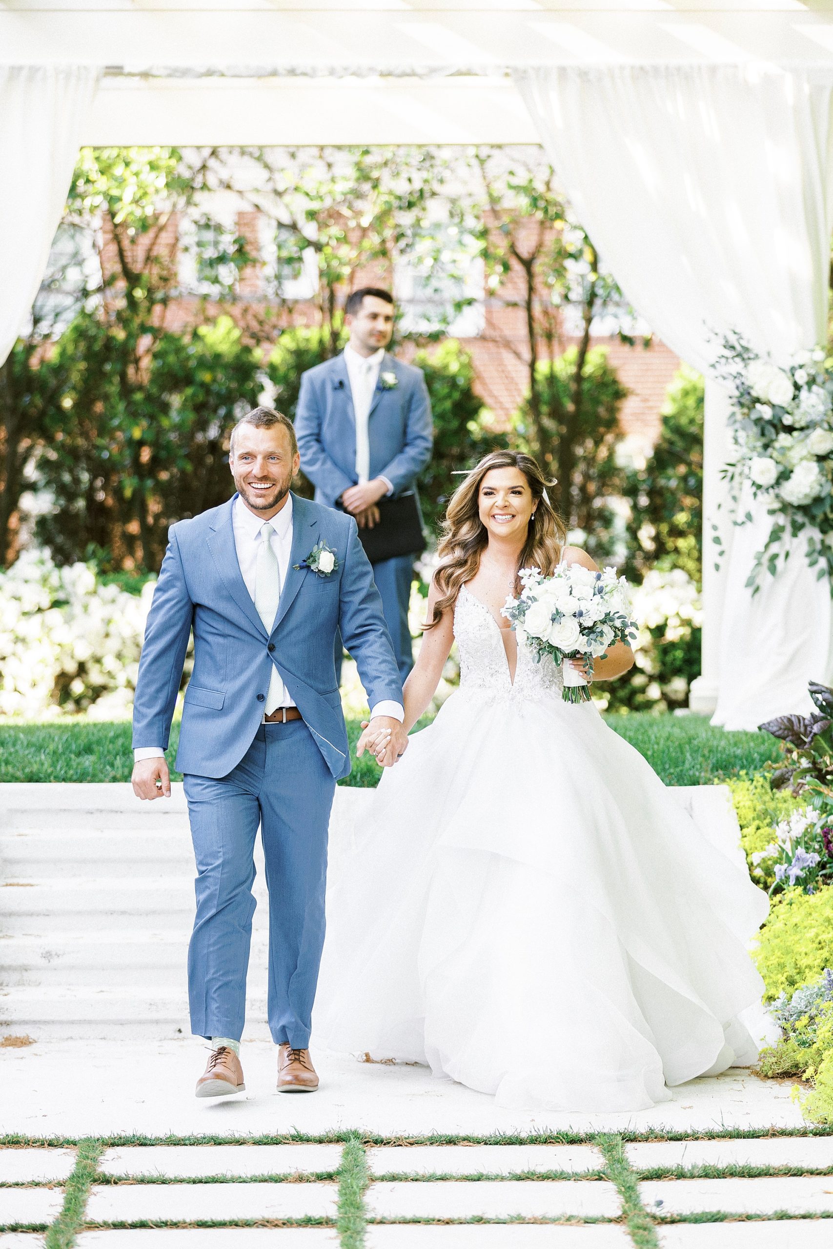 bride and groom hold hands walking up aisle at Separk Mansion