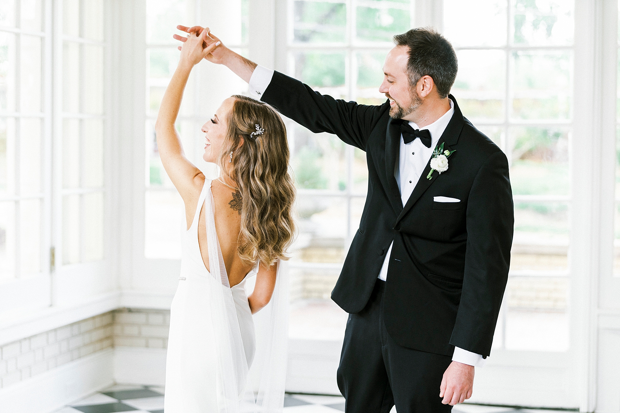 groom twirls bride in sunroom at Separk Mansion