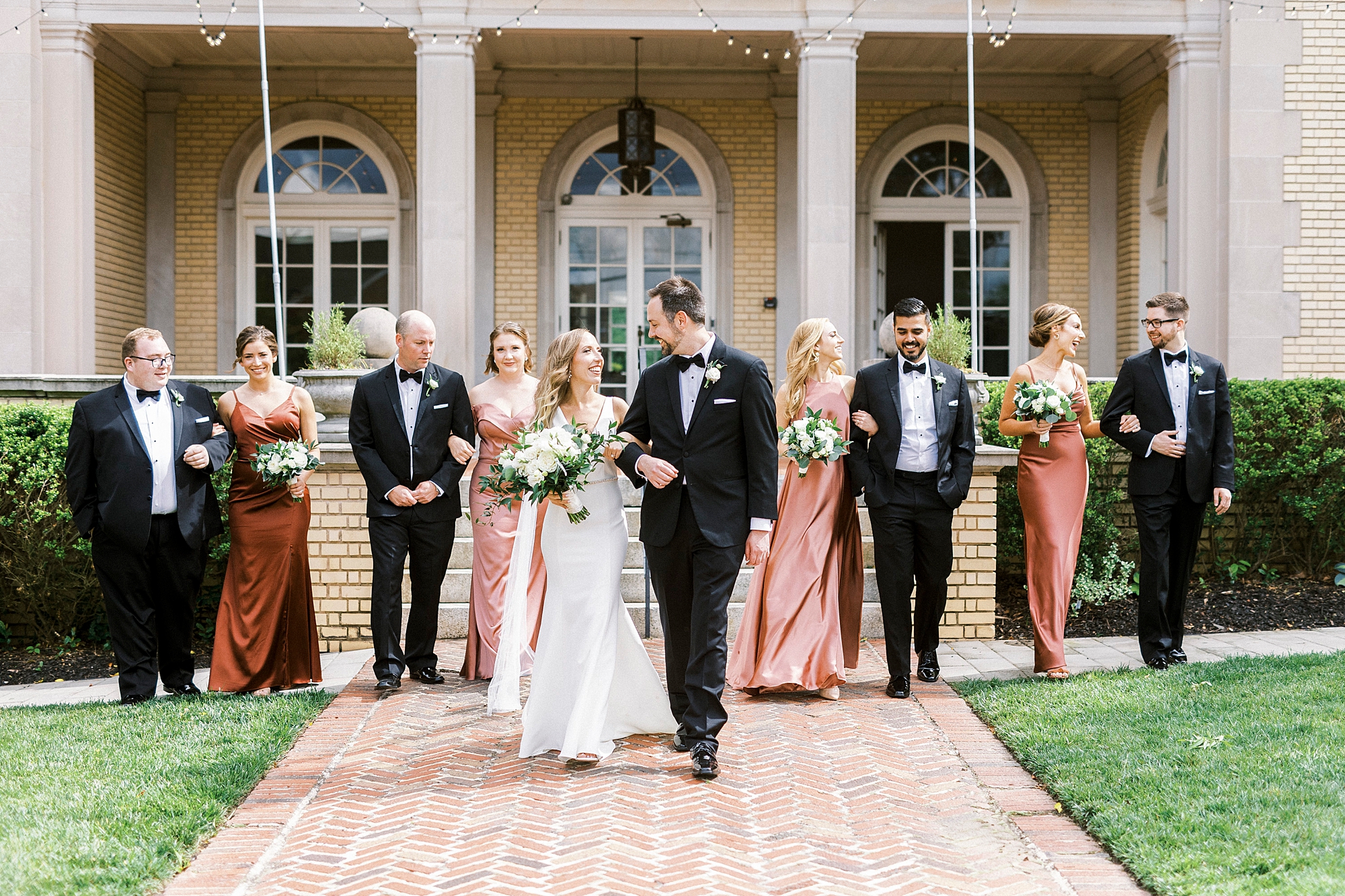 newlyweds walk with wedding party at Separk Mansion