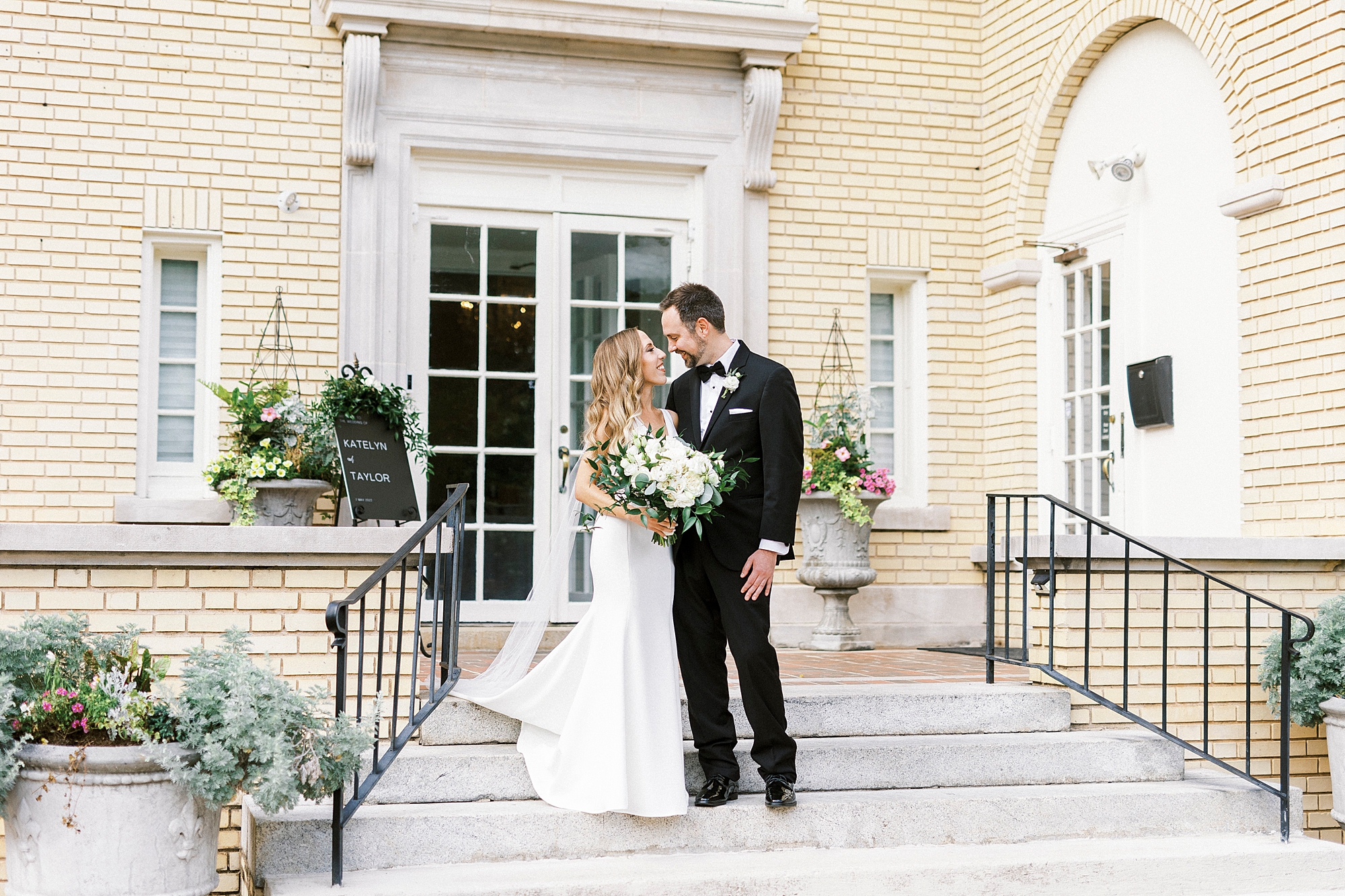 bride and groom stand on steps outside Separk Mansion