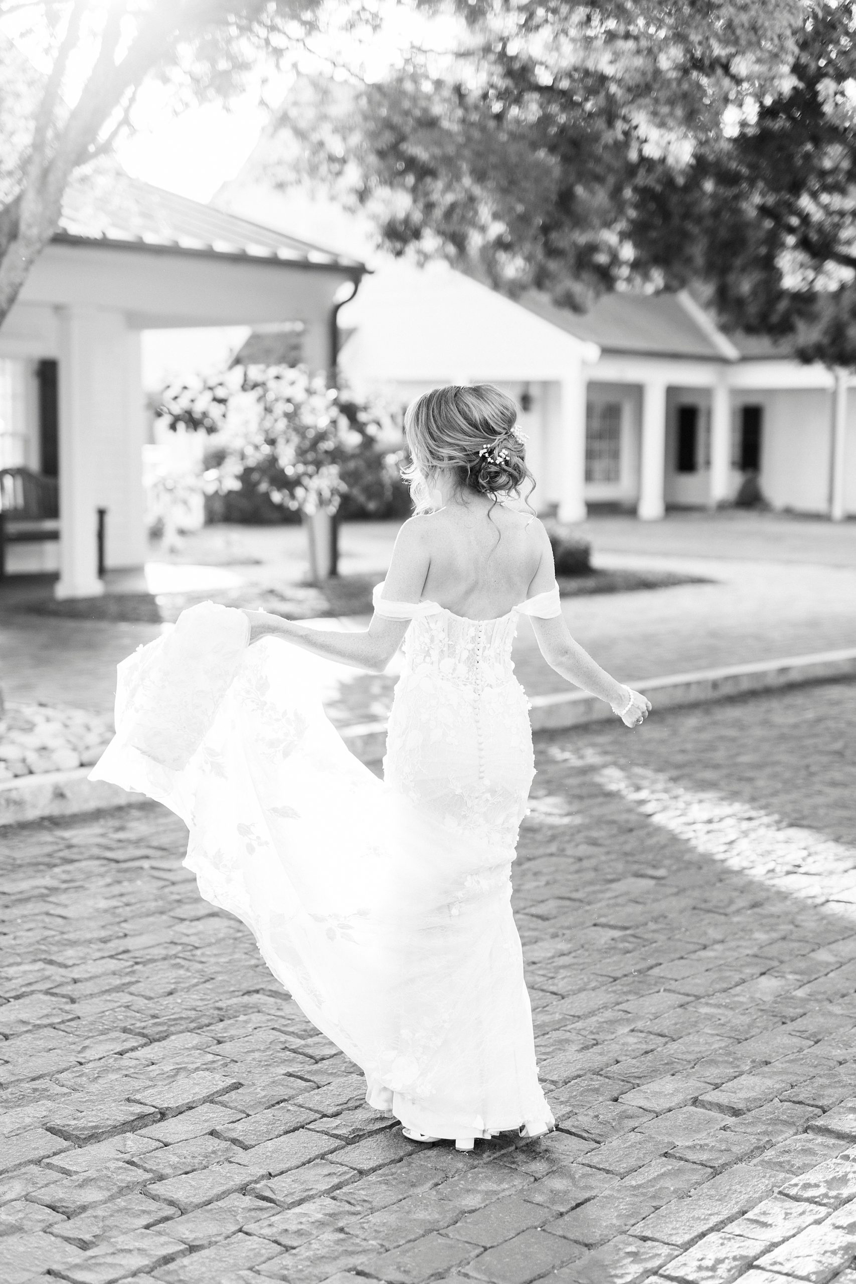 bride holds skirt of wedding dress walking through Trump National Golf Club