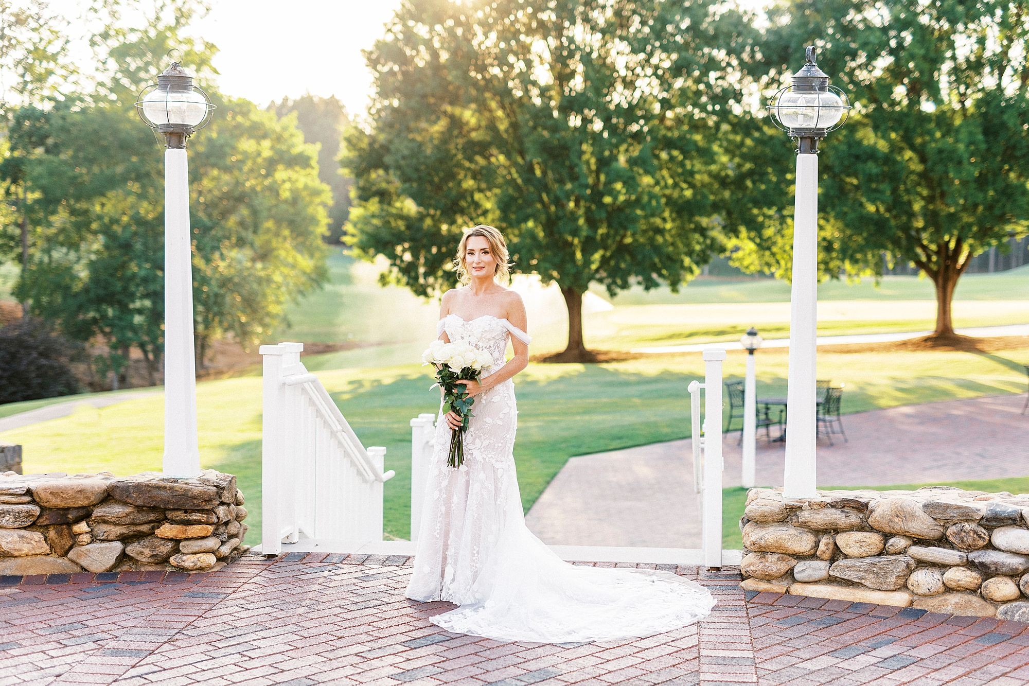 bride holds bouquet of white flowers during sunset Trump National Golf Club bridal portraits
