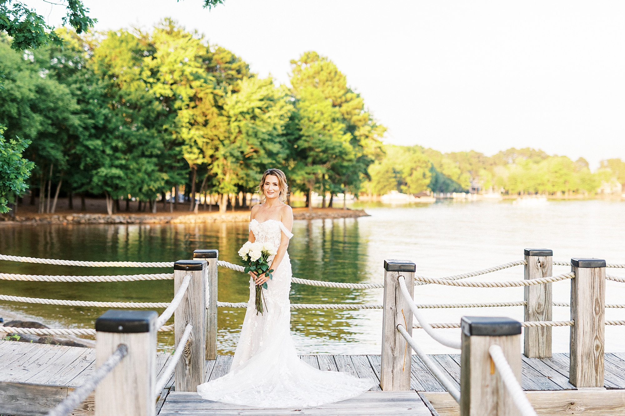 bride stands on wooden dock during bridal session at Trump National Golf Club