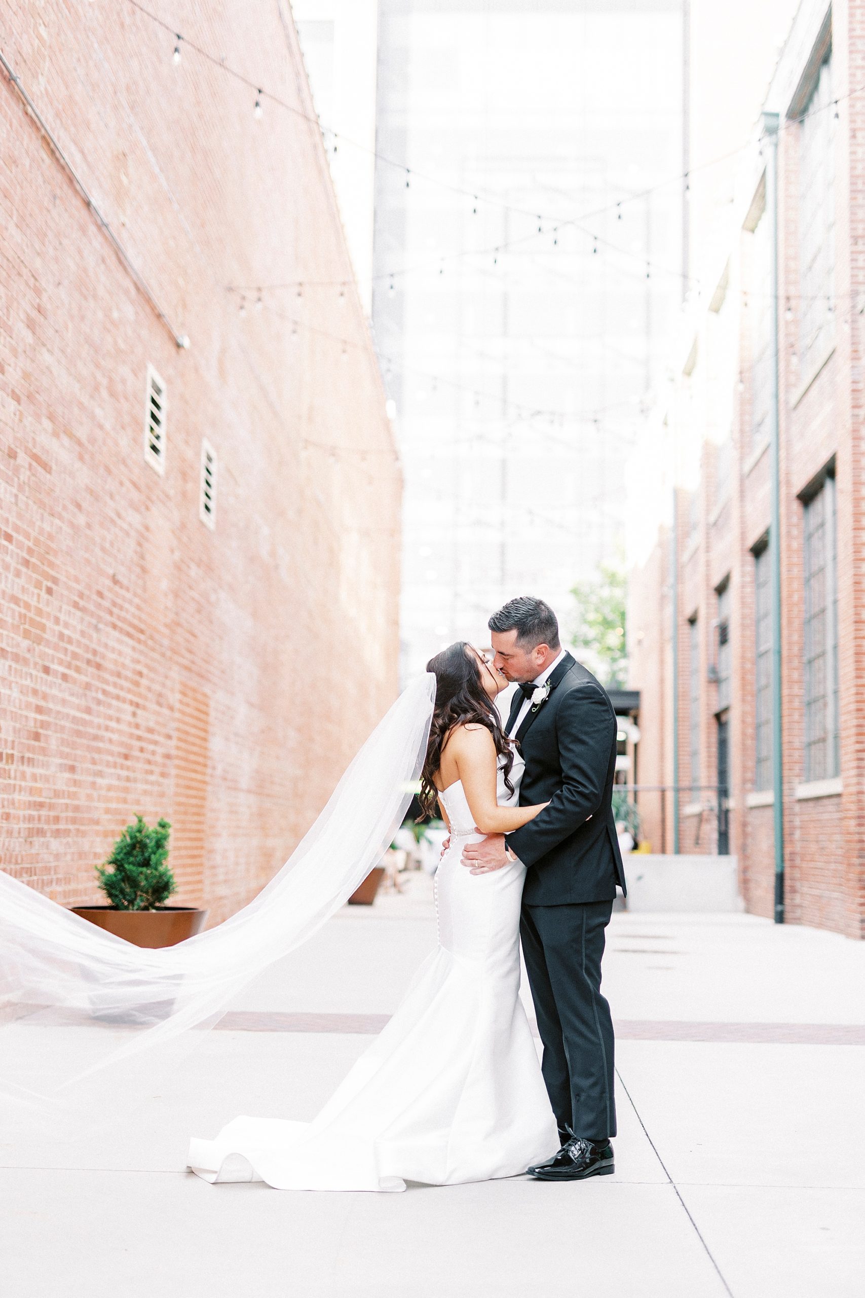 bride and groom kiss in alley by Byron's South End