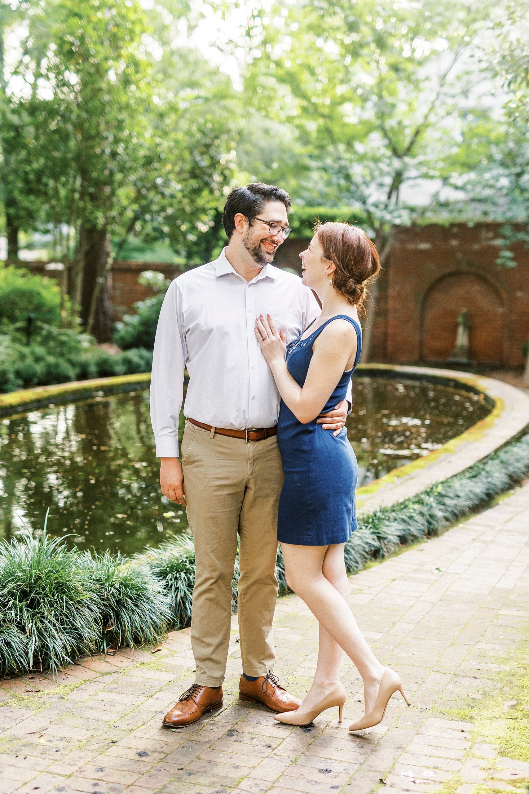 husband and wife pose along brick walkway during anniversary photos at Wing Haven Garden