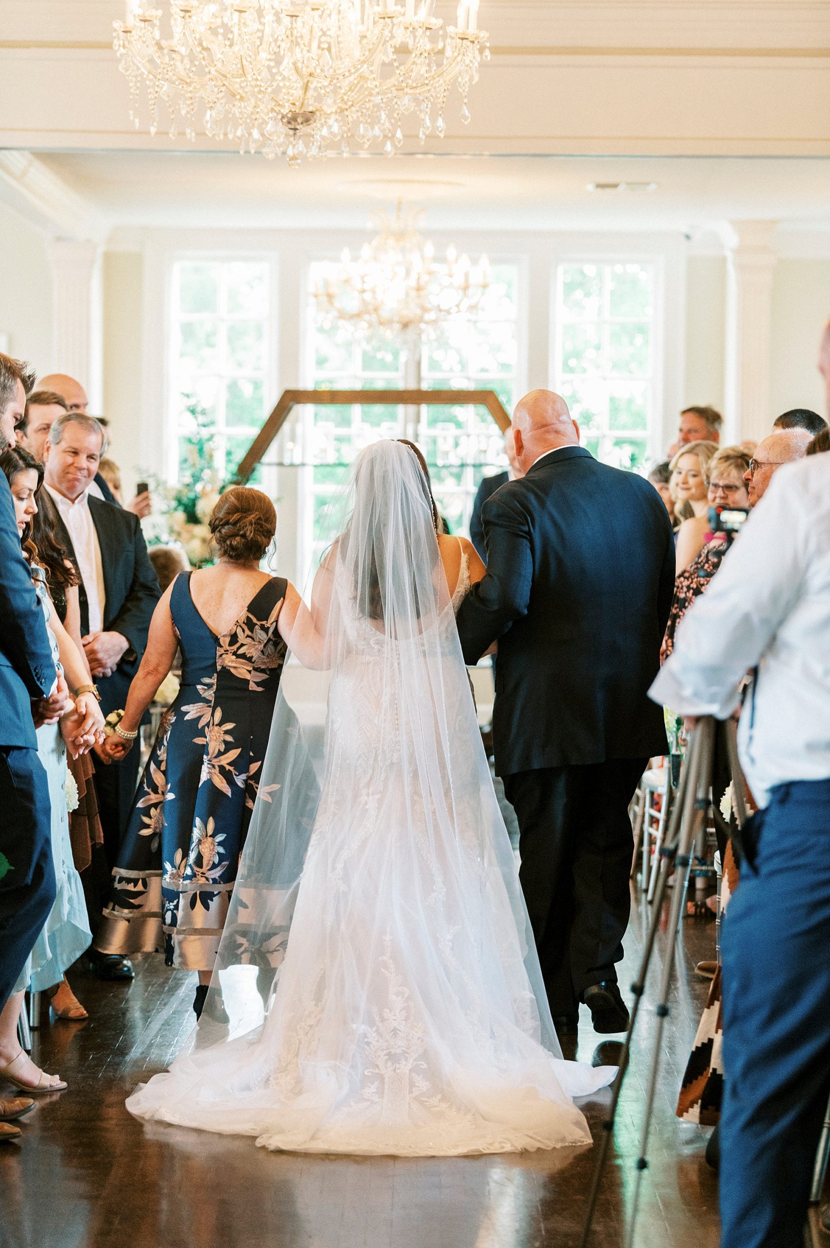 parents walk daughter down aisle for indoor wedding ceremony at Separk Mansion