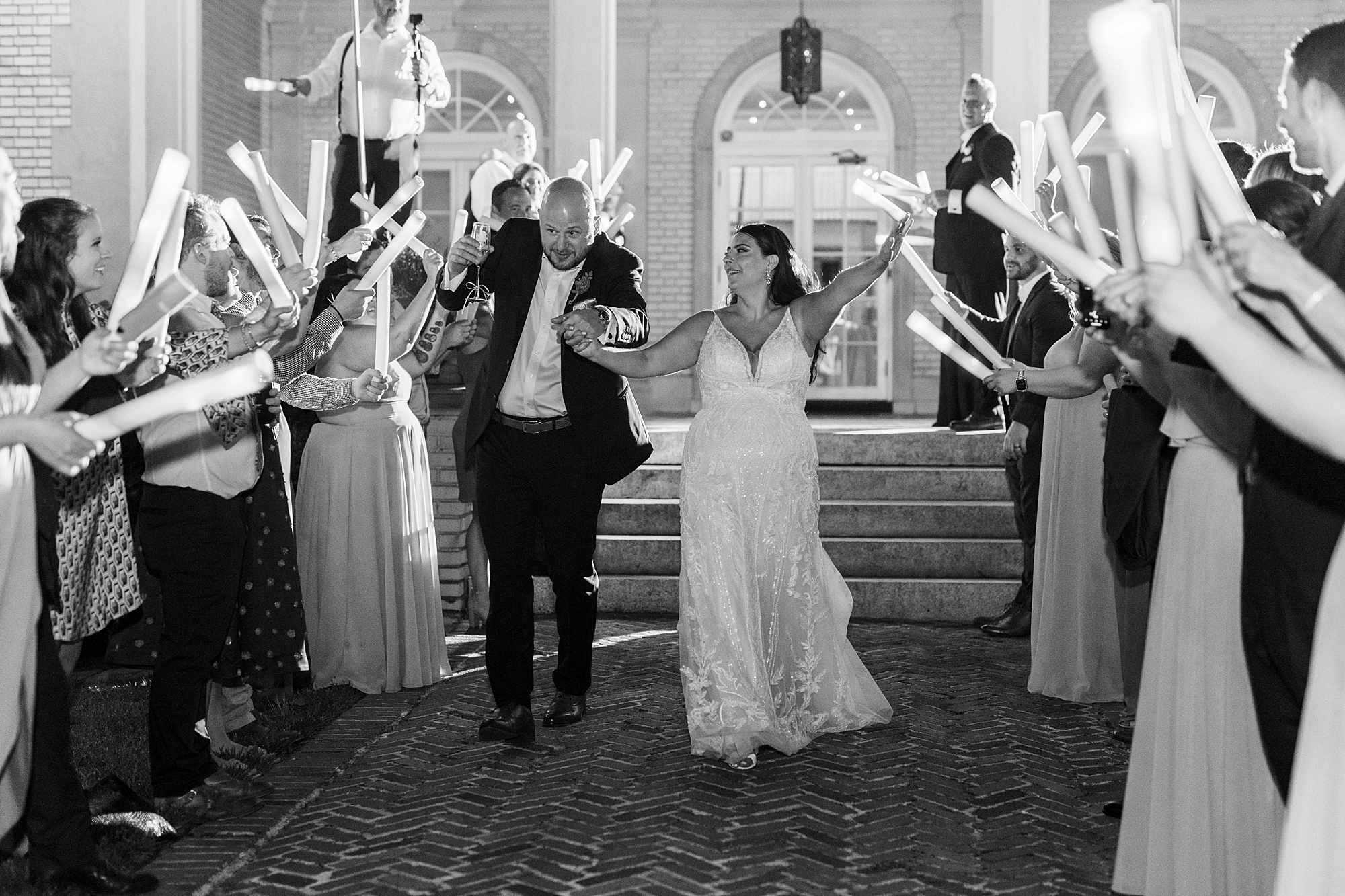 newlyweds cheer through glow stick exit at NC wedding reception