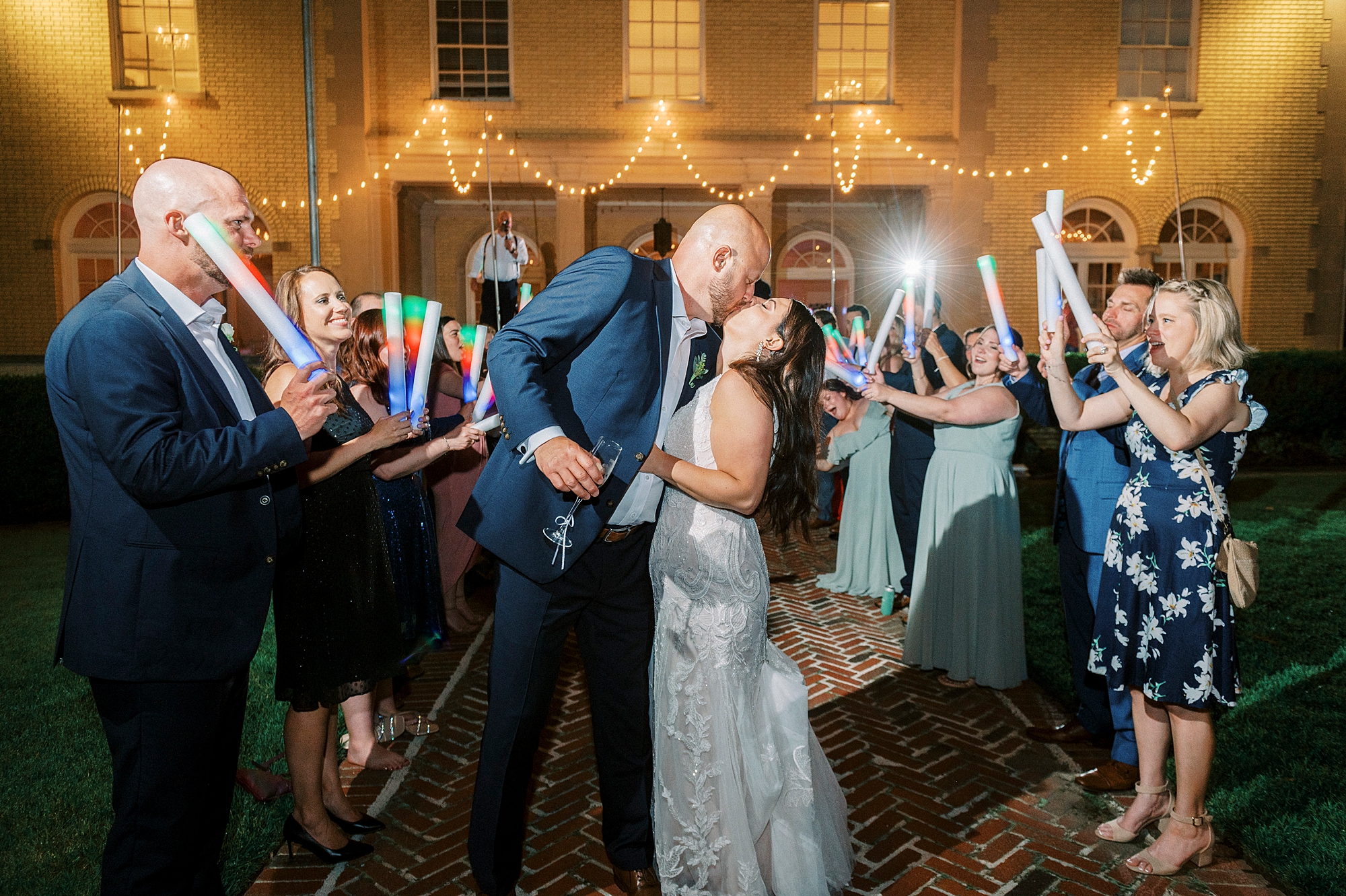 bride and groom kiss during glow stick exit at NC wedding reception