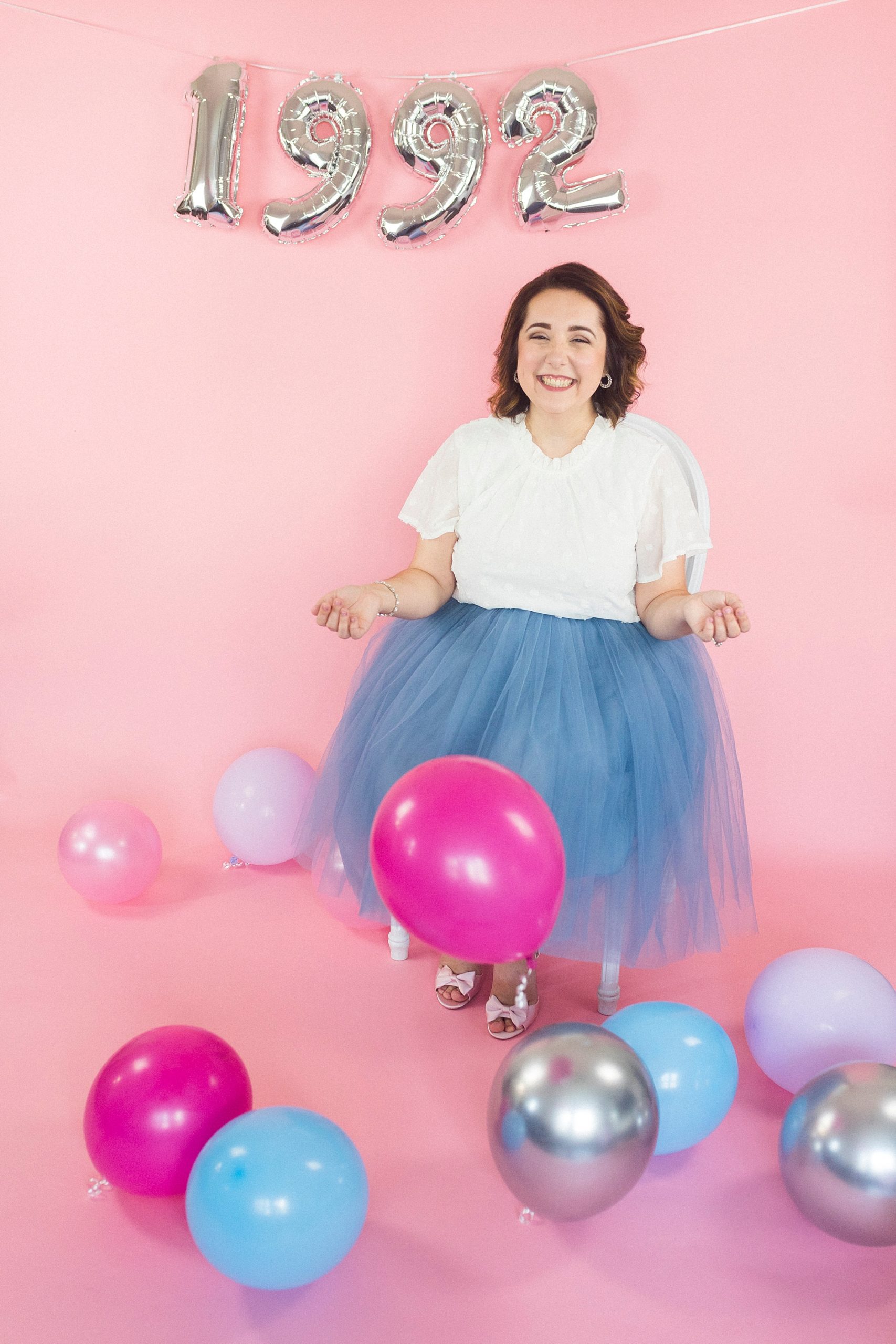 30th Birthday Portraits against pink backdrop with pink and blue balloons