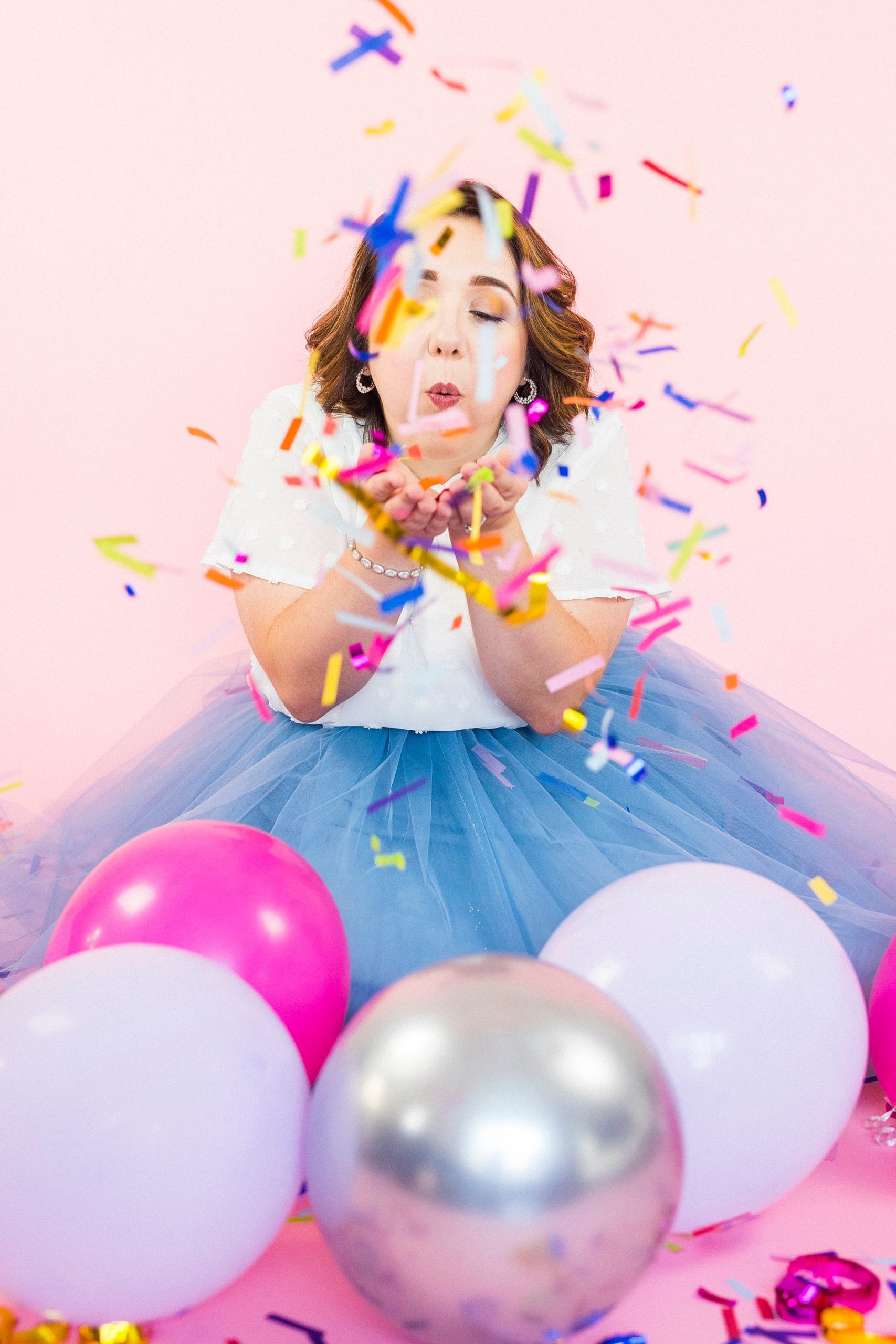 woman blows confetti out of hands during 30th birthday portraits