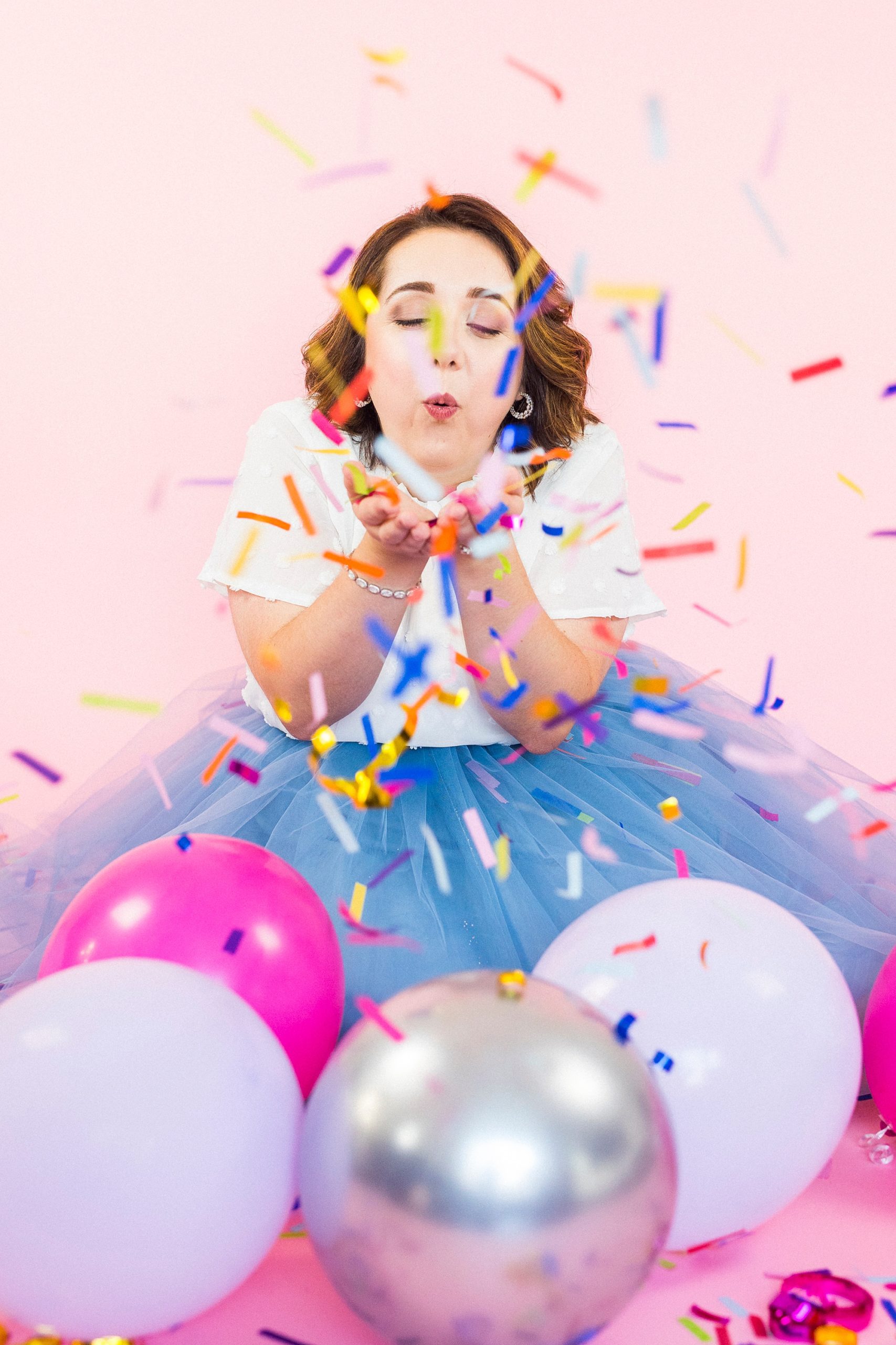 birthday girl blows confetti out of her hands during 30th birthday portraits