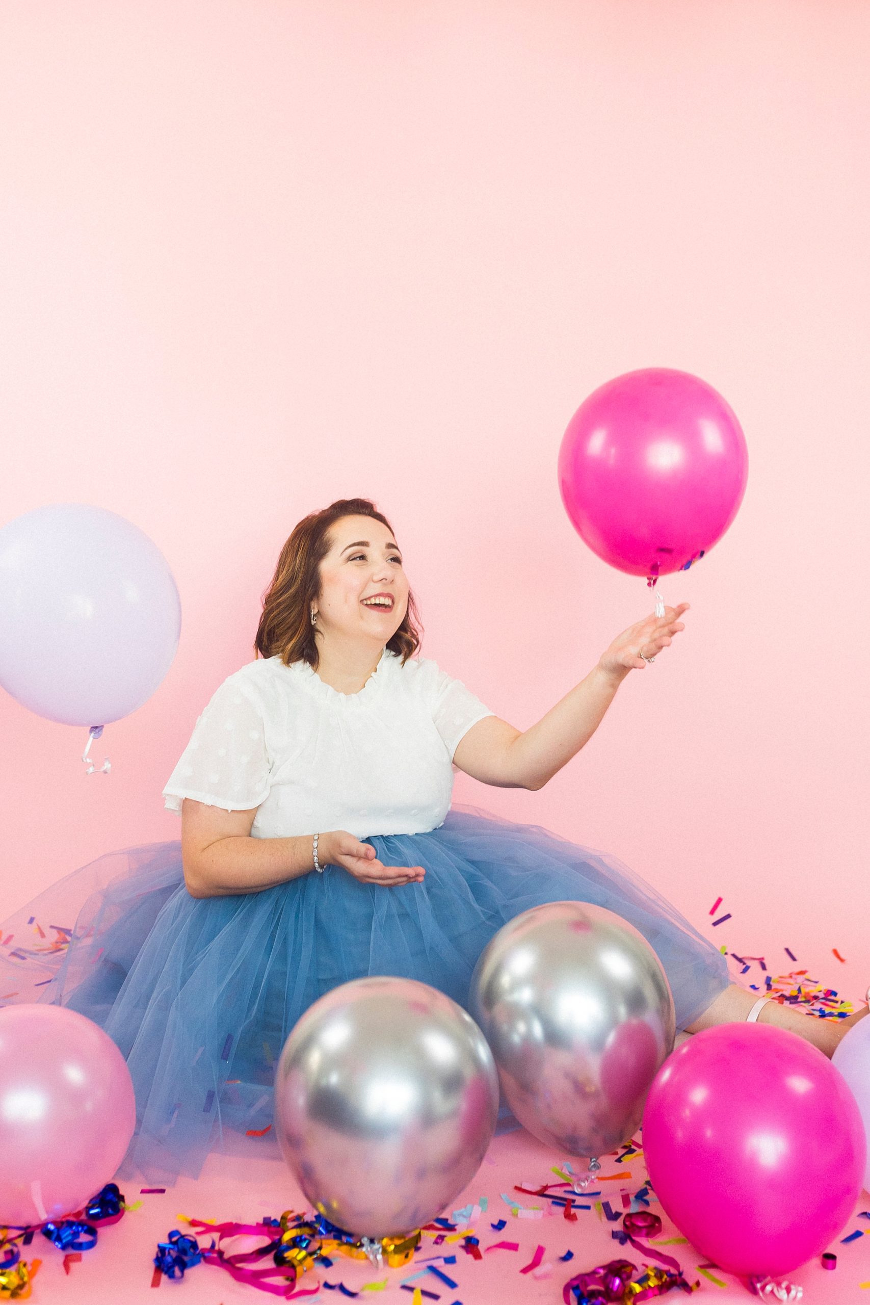 woman lifts pink balloon during 30th birthday portraits