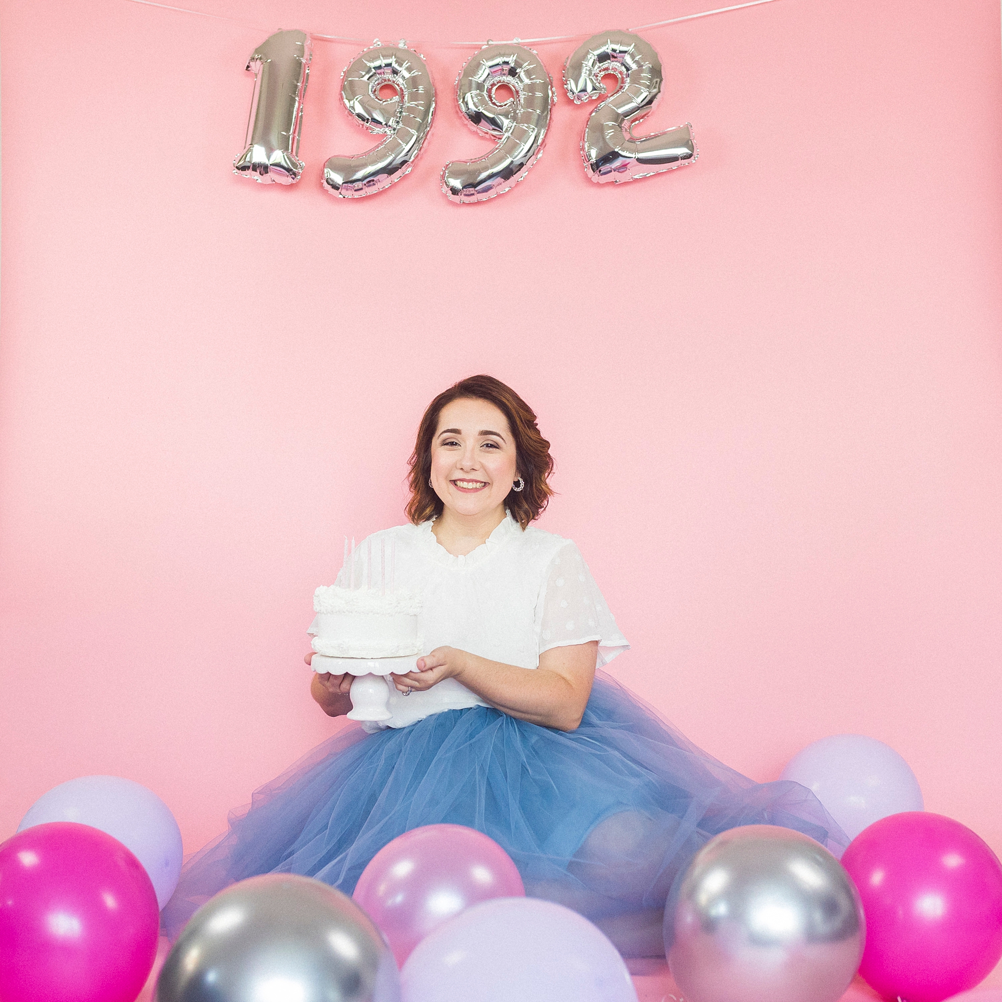 woman sits under 1992 balloons during 30th Birthday Portraits