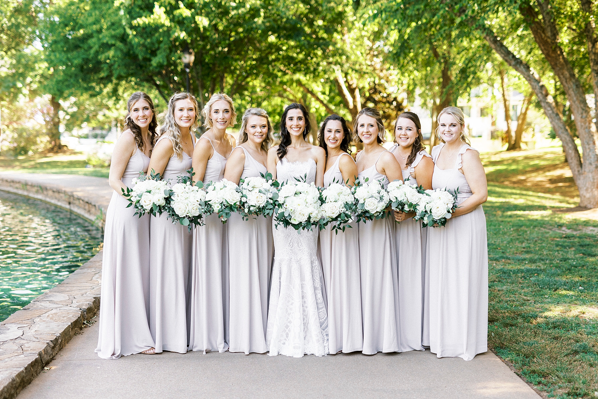 bride poses with bridesmaids in pale pink gowns in Freedom Park