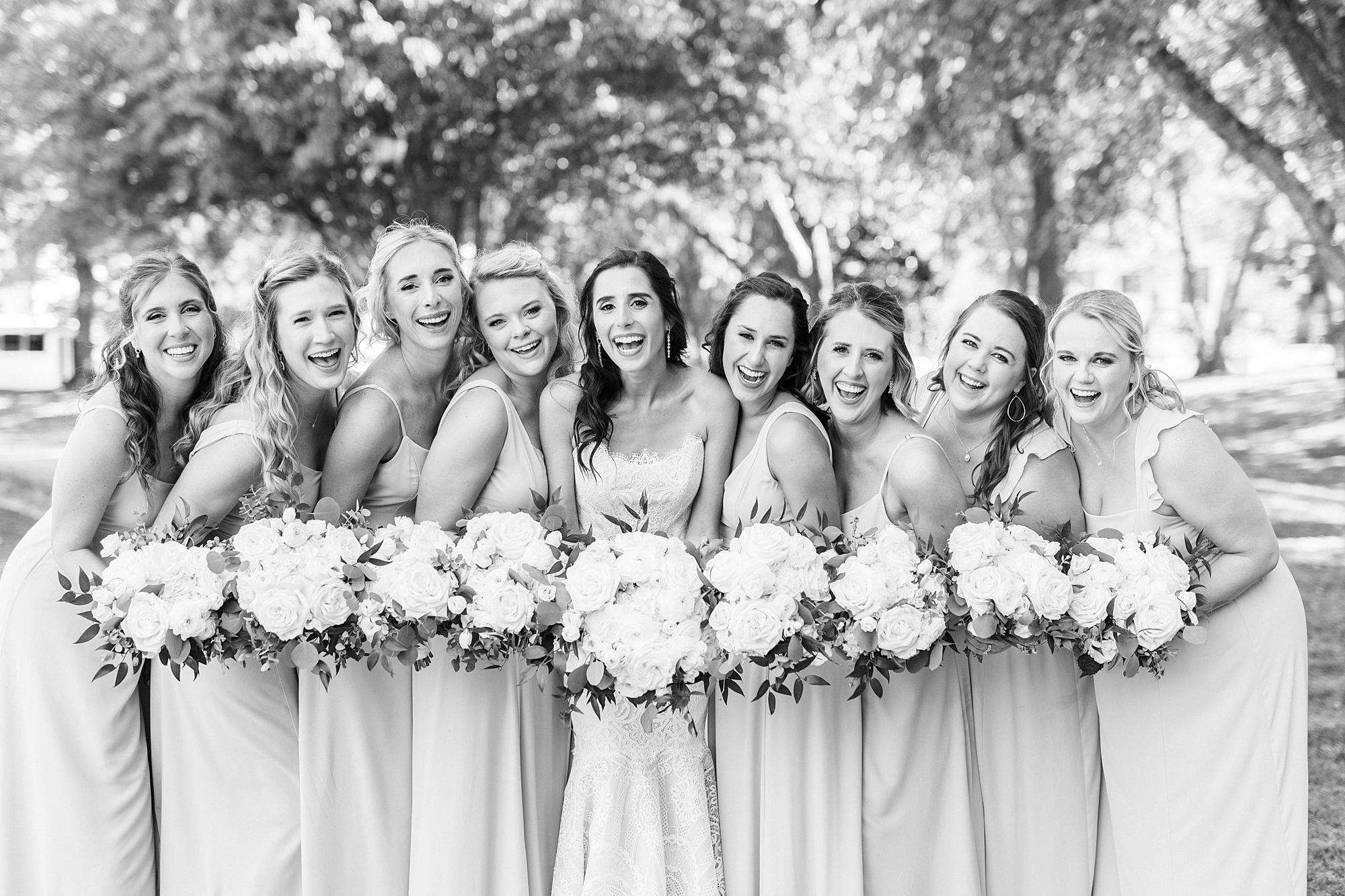 bride and bridesmaids hug together during portraits at Freedom Park