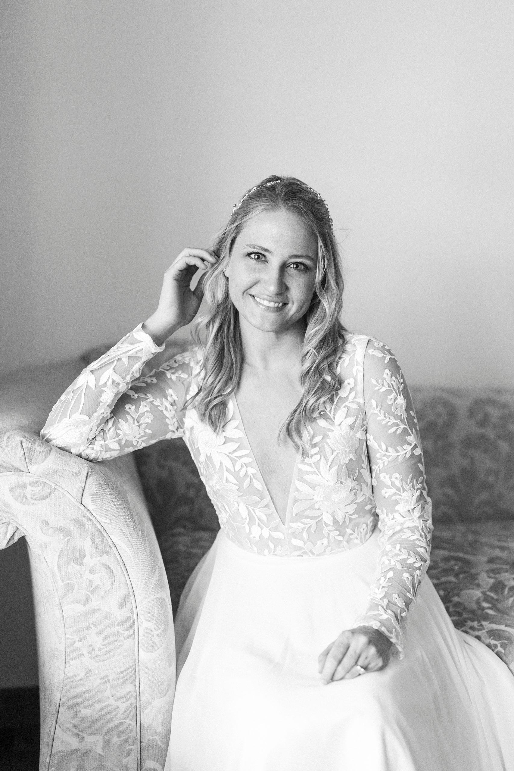 bride sits on couch during elegant bridal portraits