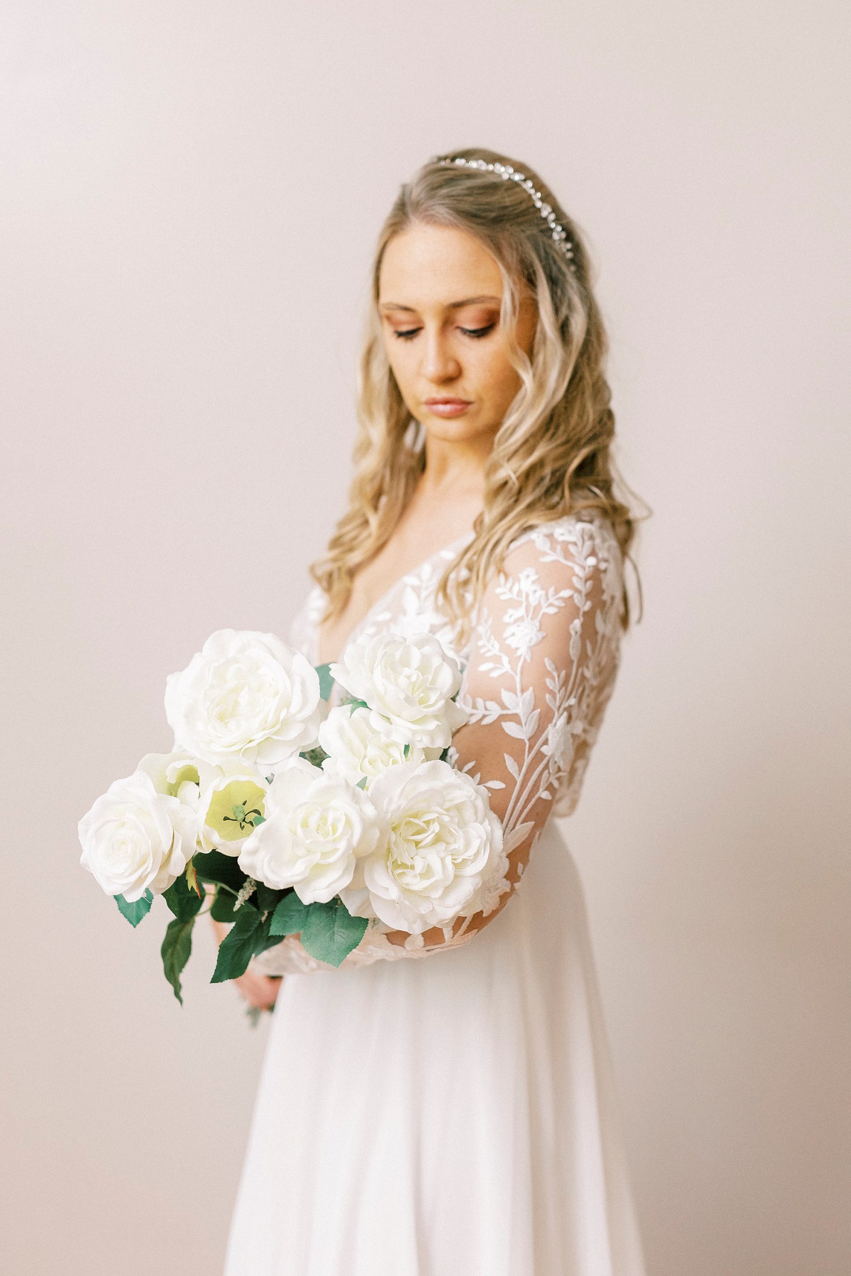 bride looks down at white bouquet during NC bridal portraits 