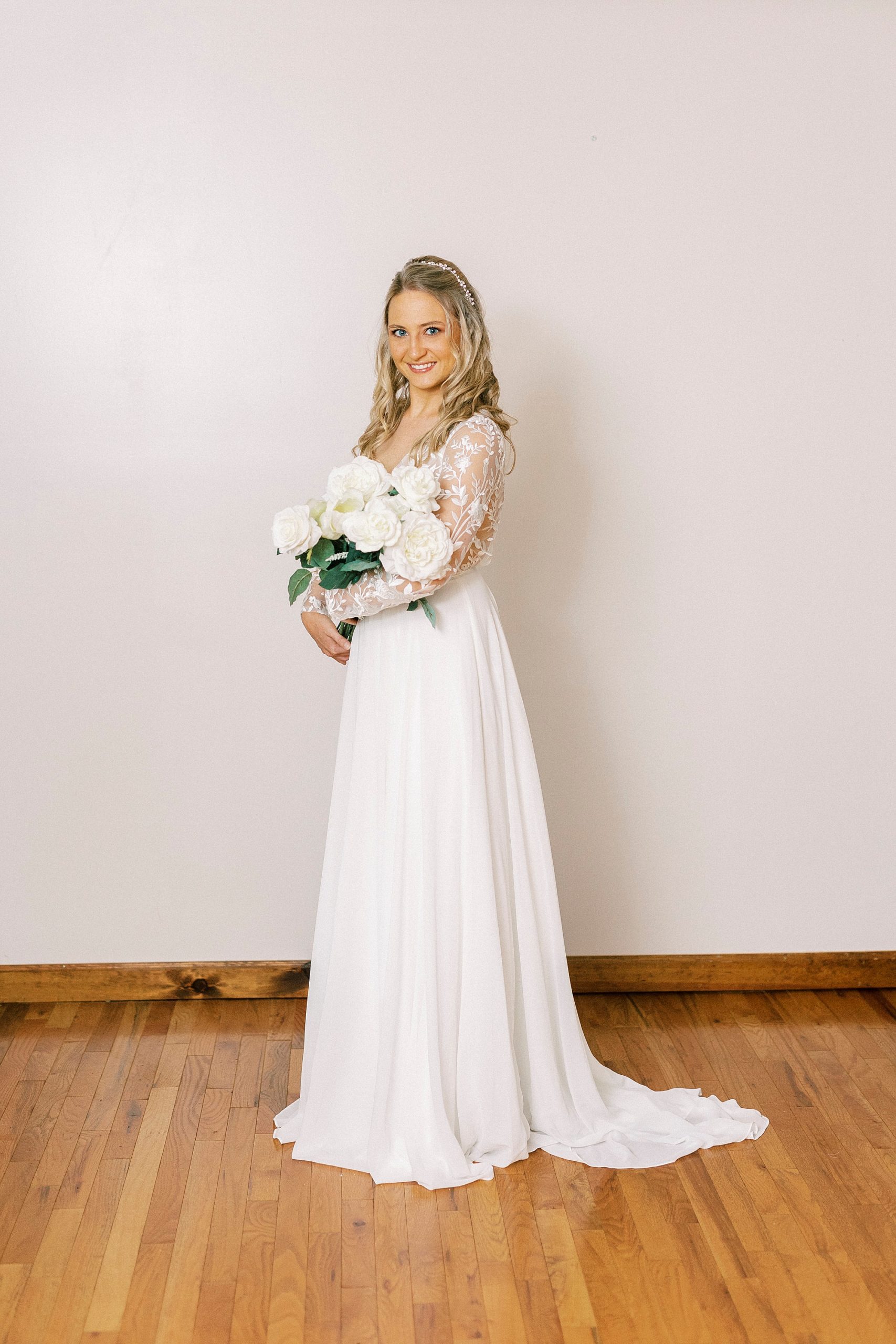 bride stands by wall in Lenoir Home during bridal portraits