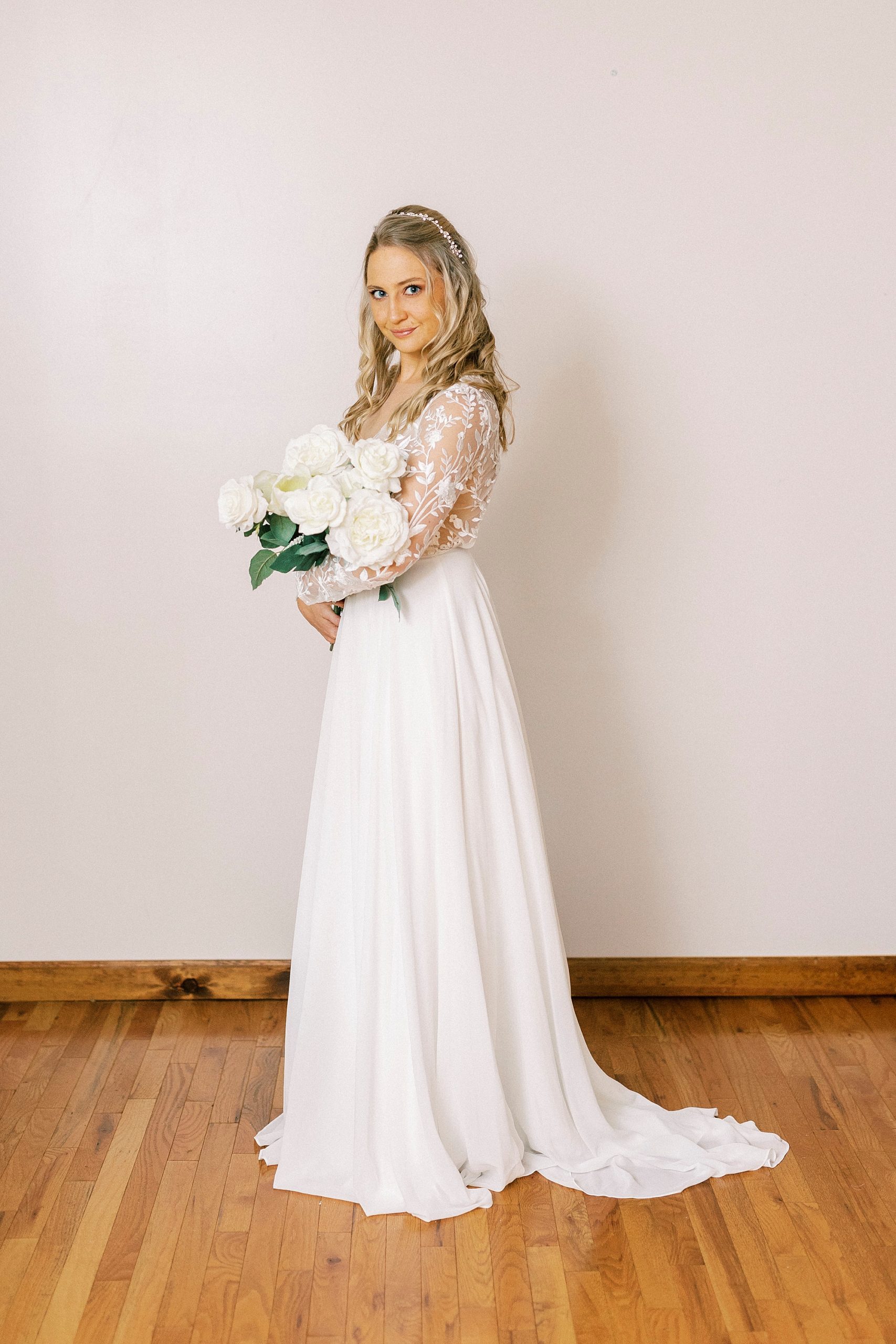 bride holds white bouquet during bridal portraits in home