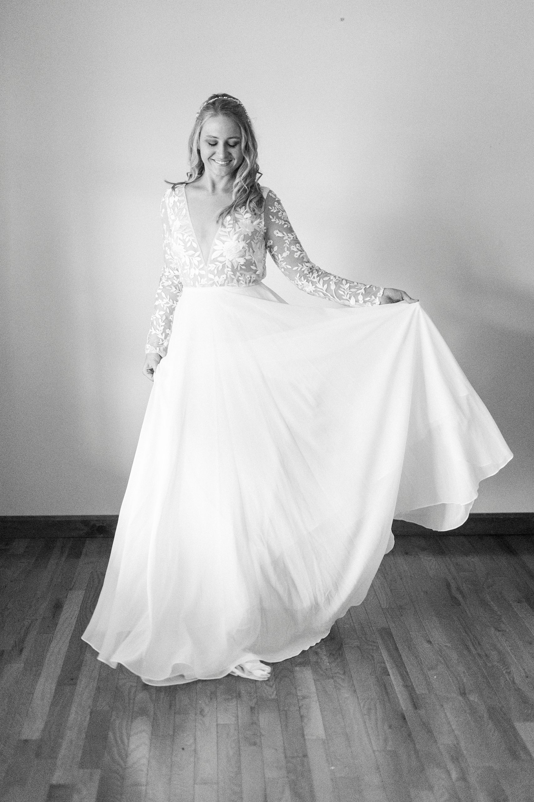 bride shows off skirt of wedding gown with lace bodice 