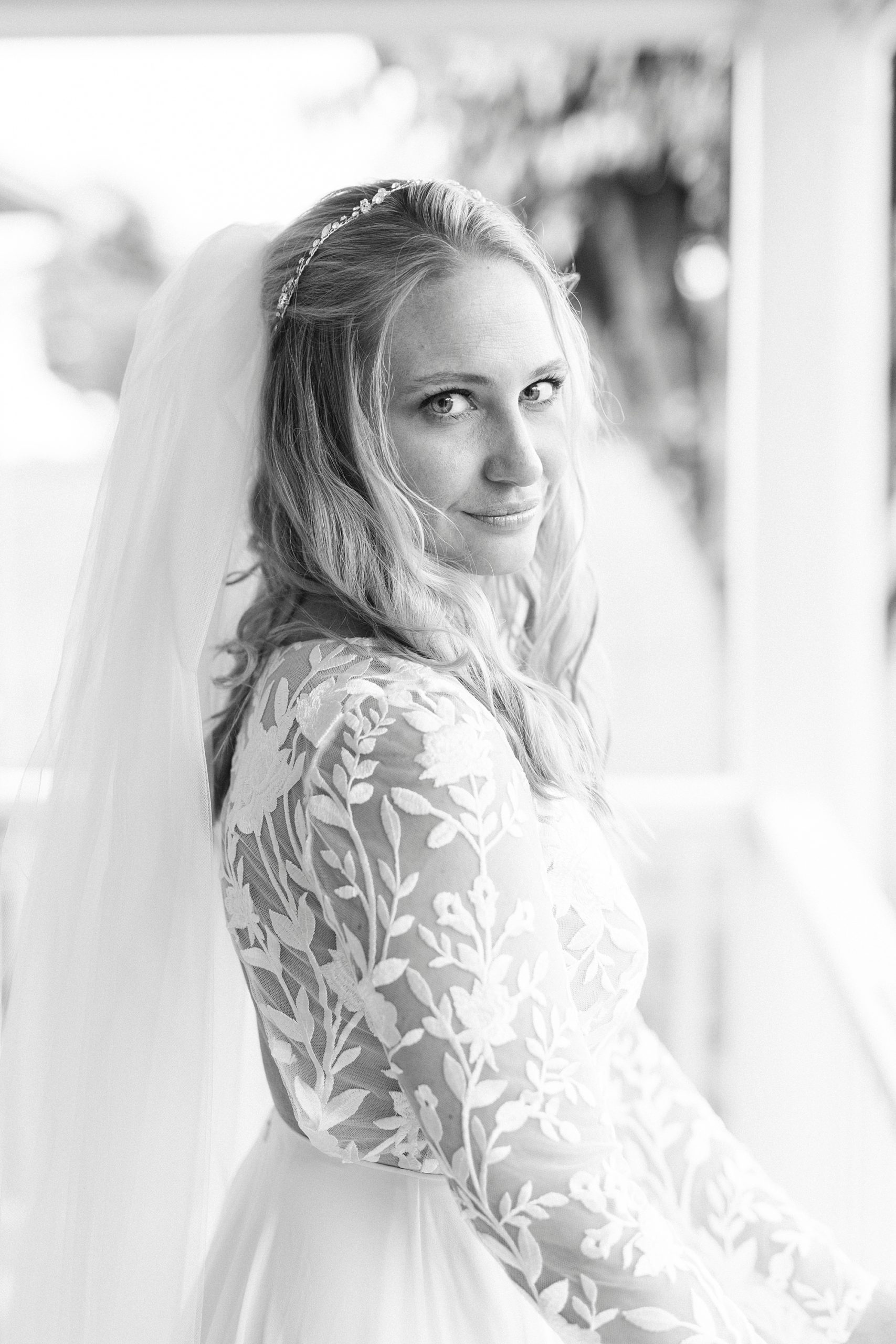 bride smirks during bridal portraits on front porch of family home 