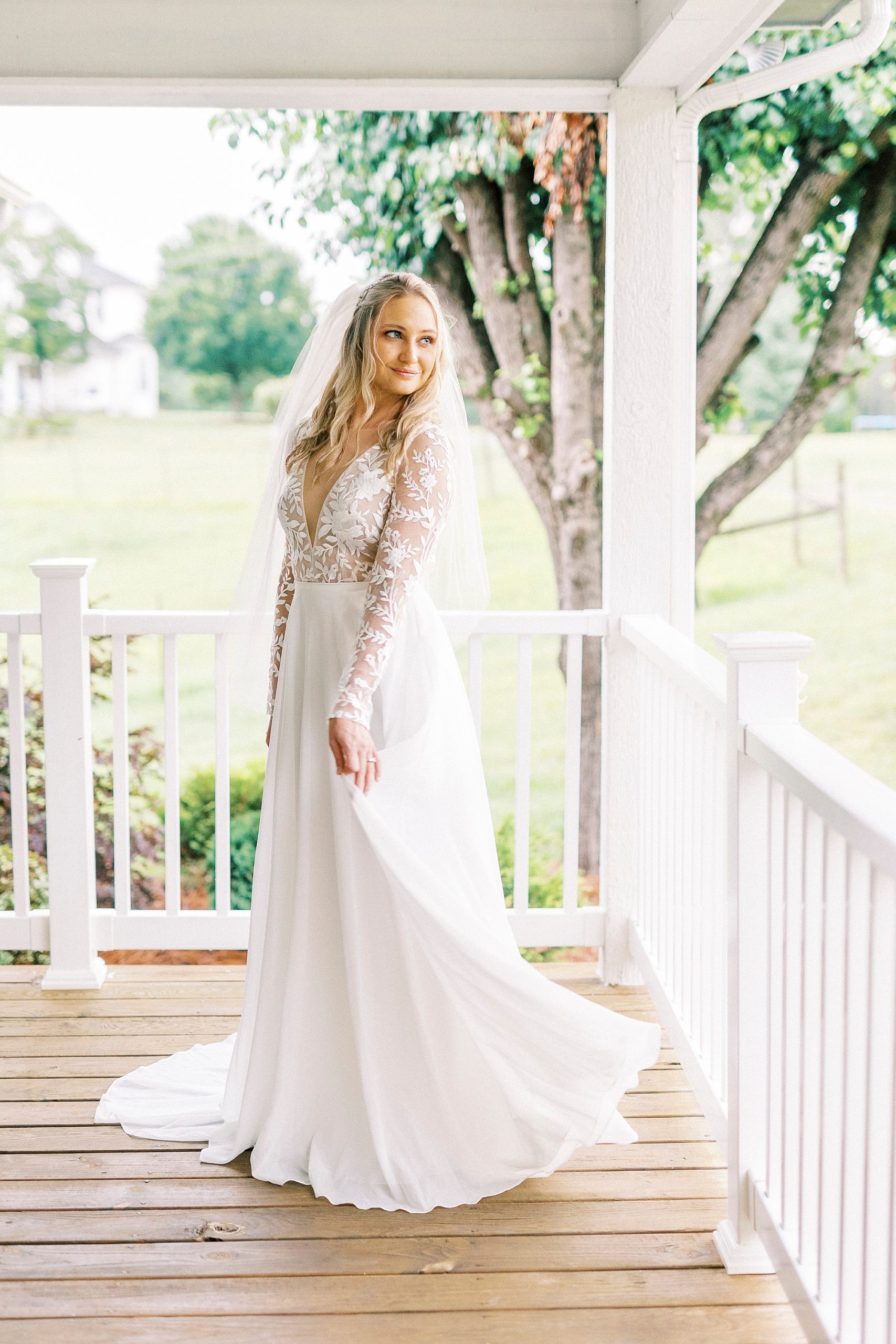 bride twirls wedding gown on porch during bridal portraits