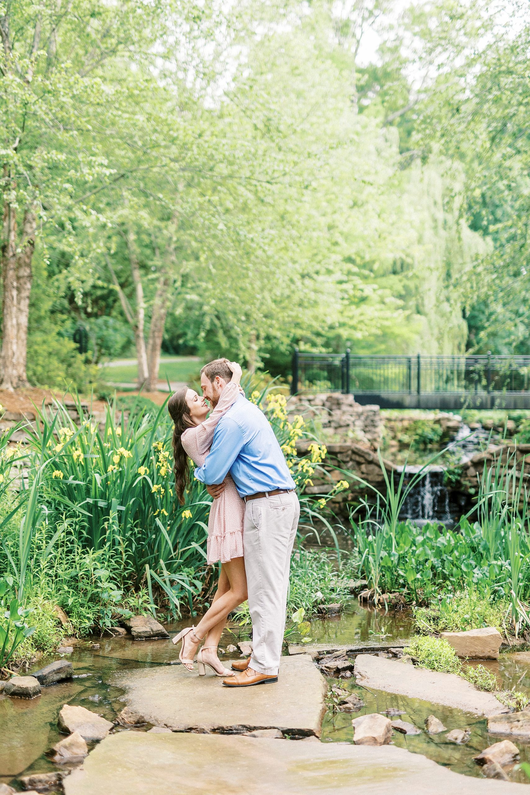 bride and groom kiss on rocks in Glencairn Gardens