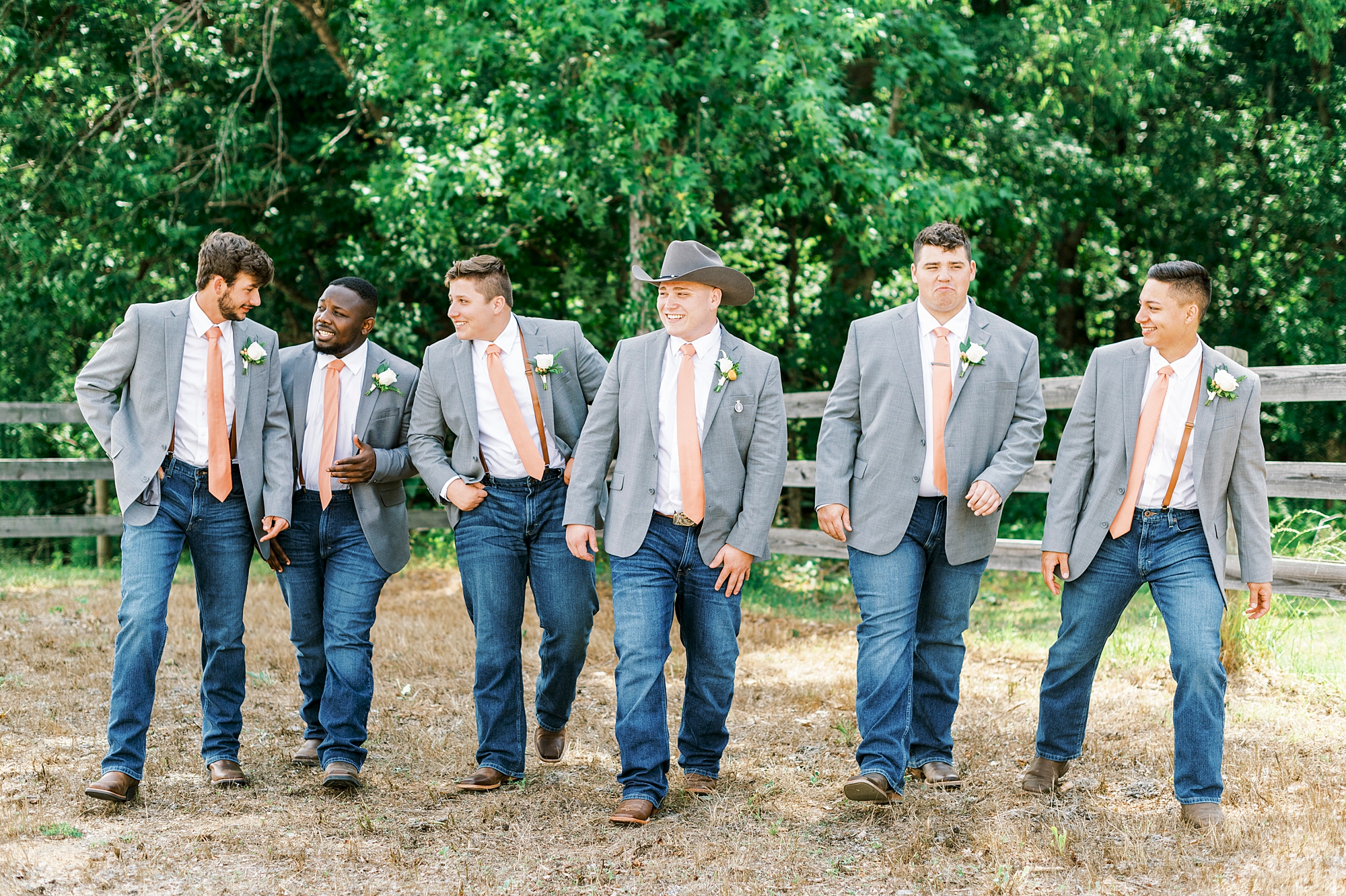 groom walks with groomsmen in suit jackets with jeans