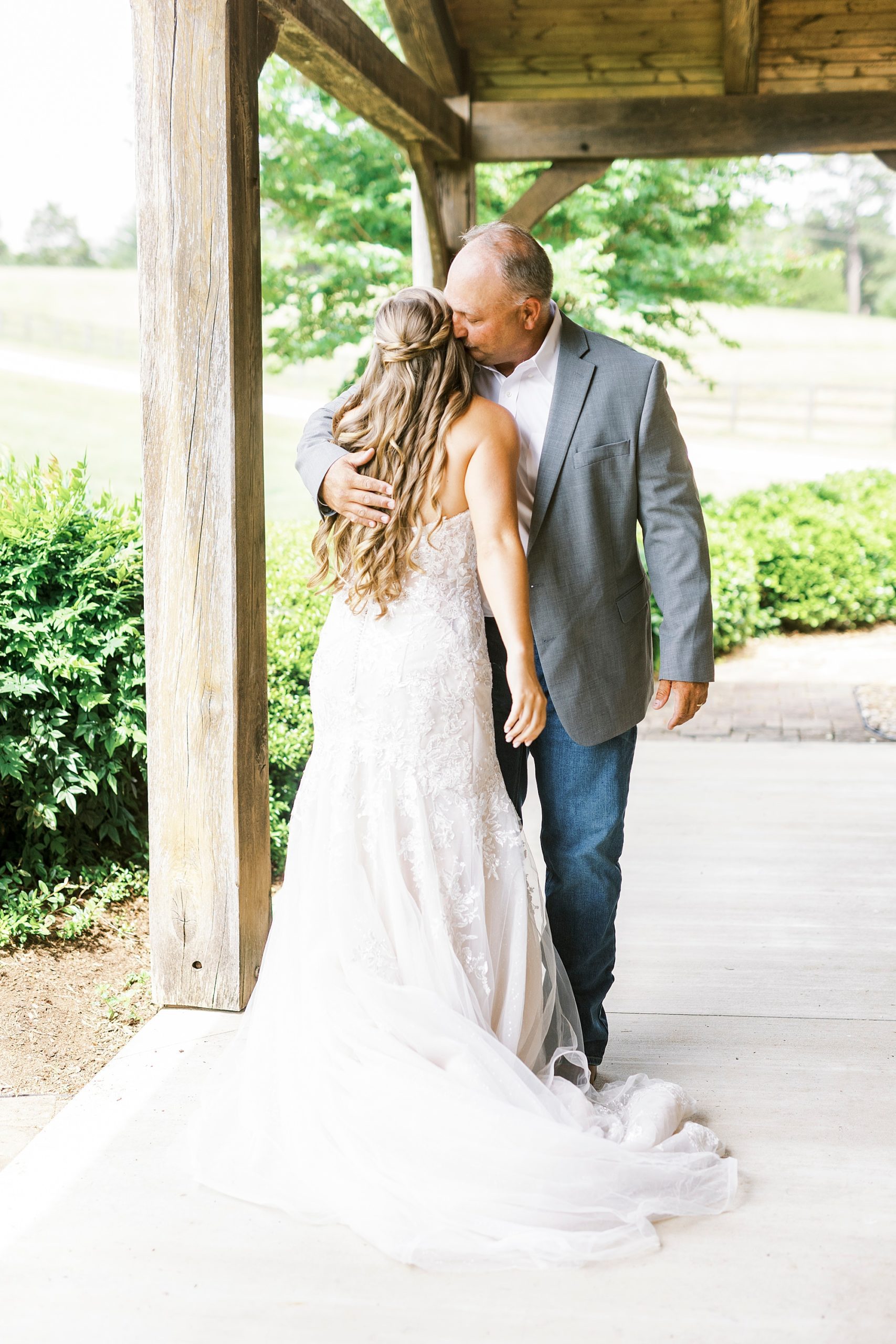 dad hugs bride during first look outside The Stable at Riverview