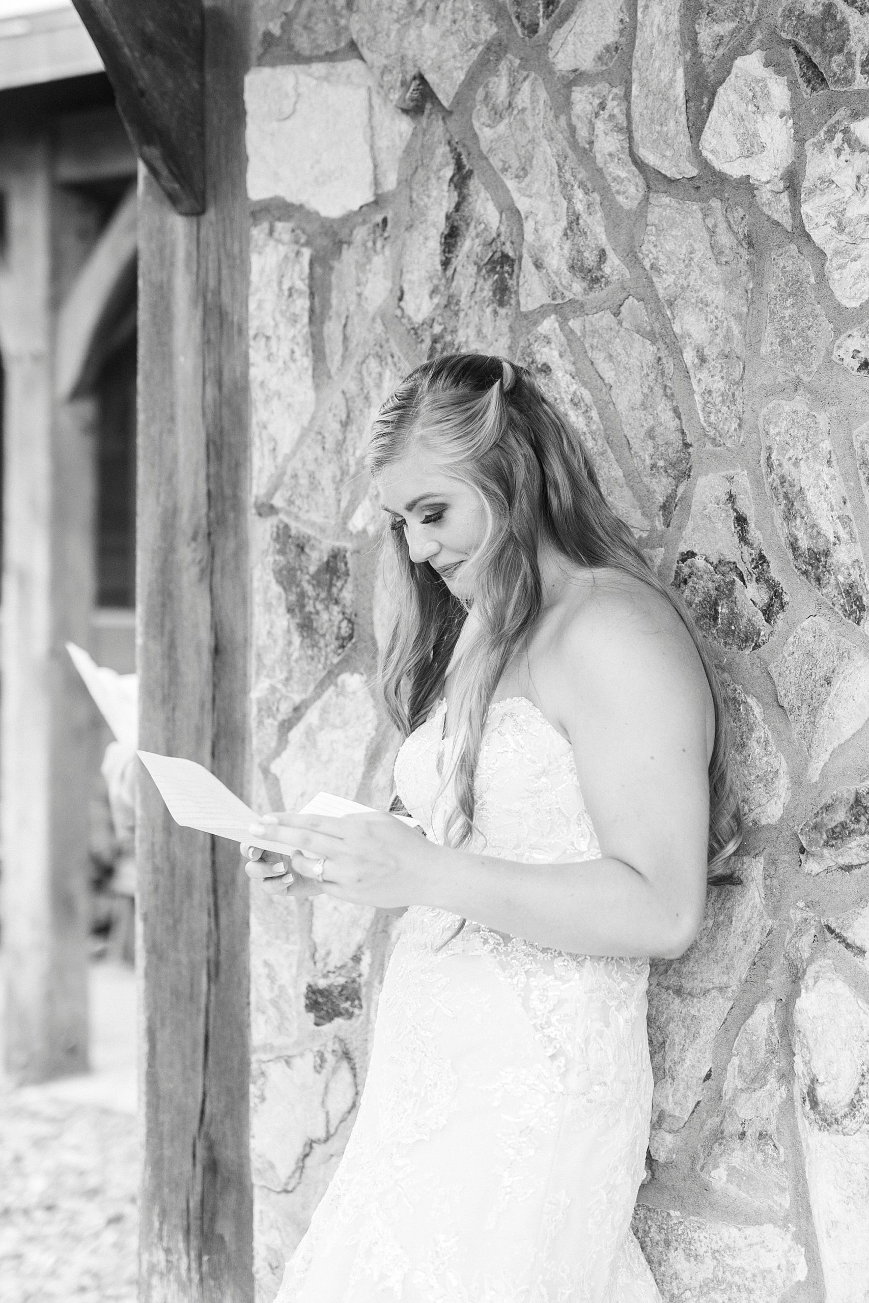 bride reads letter from groom on wedding day at The Stable at Riverview