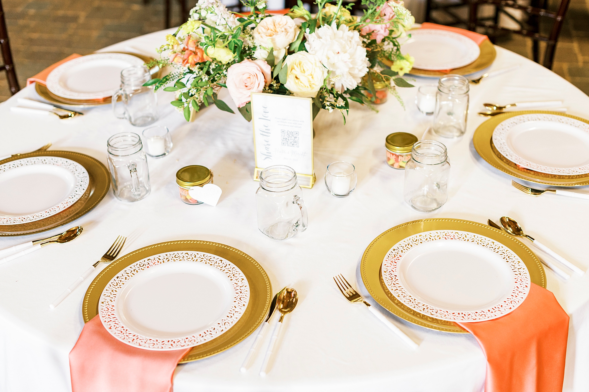 place setting for rustic wedding with gold rimmed plates and colorful napkins